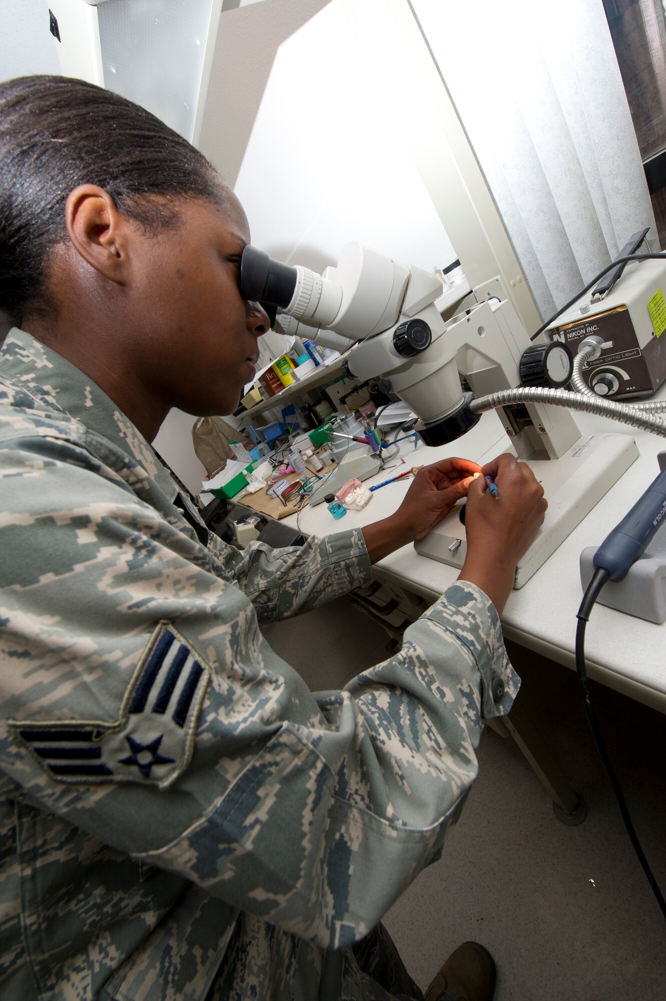 Senior Airman Melissa Barnes, 49th Aeromedical Squadron dental laboratory technician, uses a microscope to check the seal of an impression at the Holloman Air Force Base, N.M., June 13. Ensuring a proper seal allows the laboratory technicians to make a more precise crown for the patient. (U.S. Air Force photo by Airman 1st Class Daniel E. Liddicoet/Released)