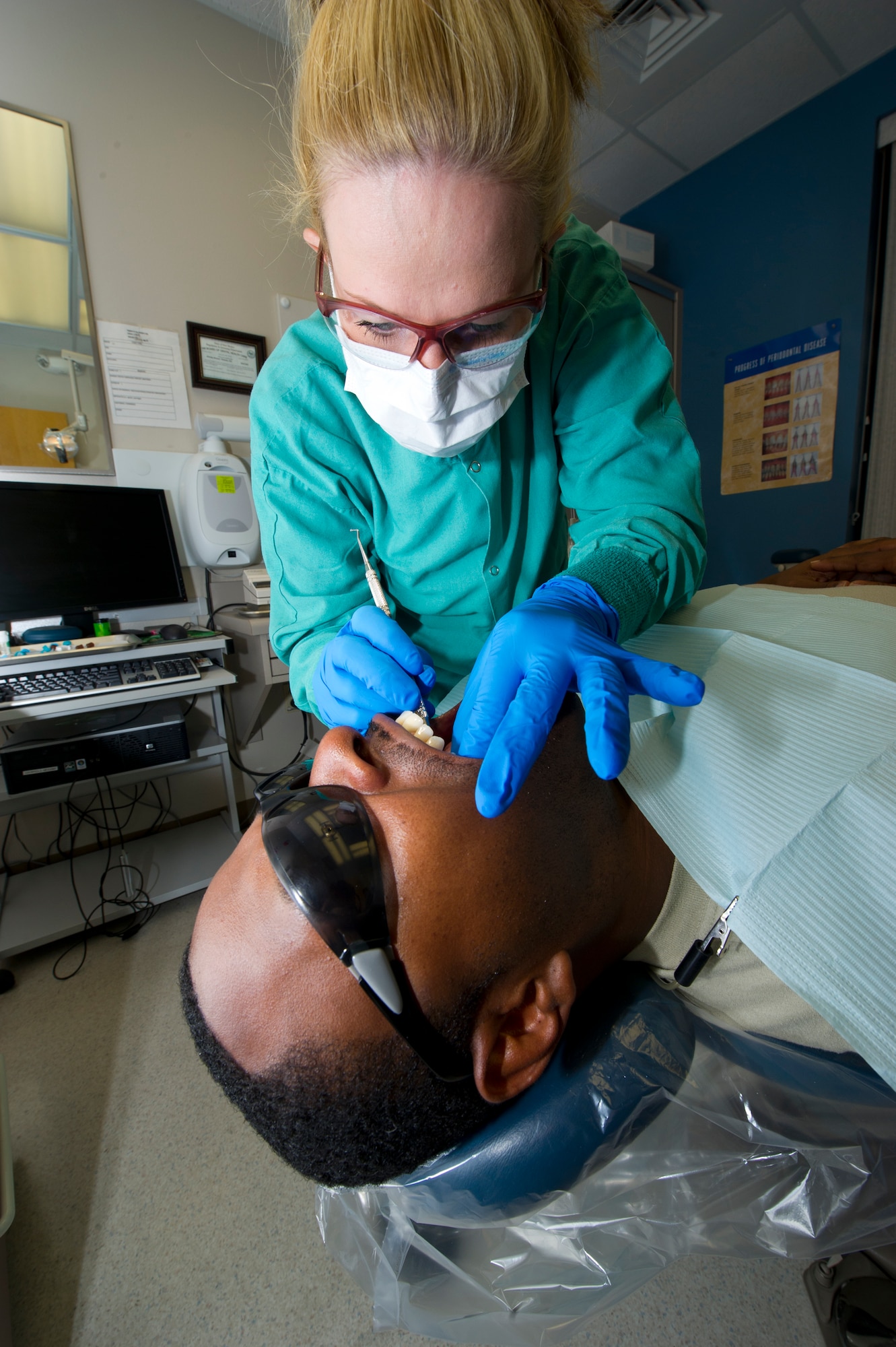 Raedawn Davis, 49th Aeromedical Squadron dental technician, cleans excess impression material out of a patient’s mouth at the Holloman Air Force Base, N.M., June 13. Different colors of the impression substance with varying qualities are used to ensure that an exact replica of the patient’s teeth can be made. (U.S. Air Force photo by Airman 1st Class Daniel E. Liddicoet/Released)