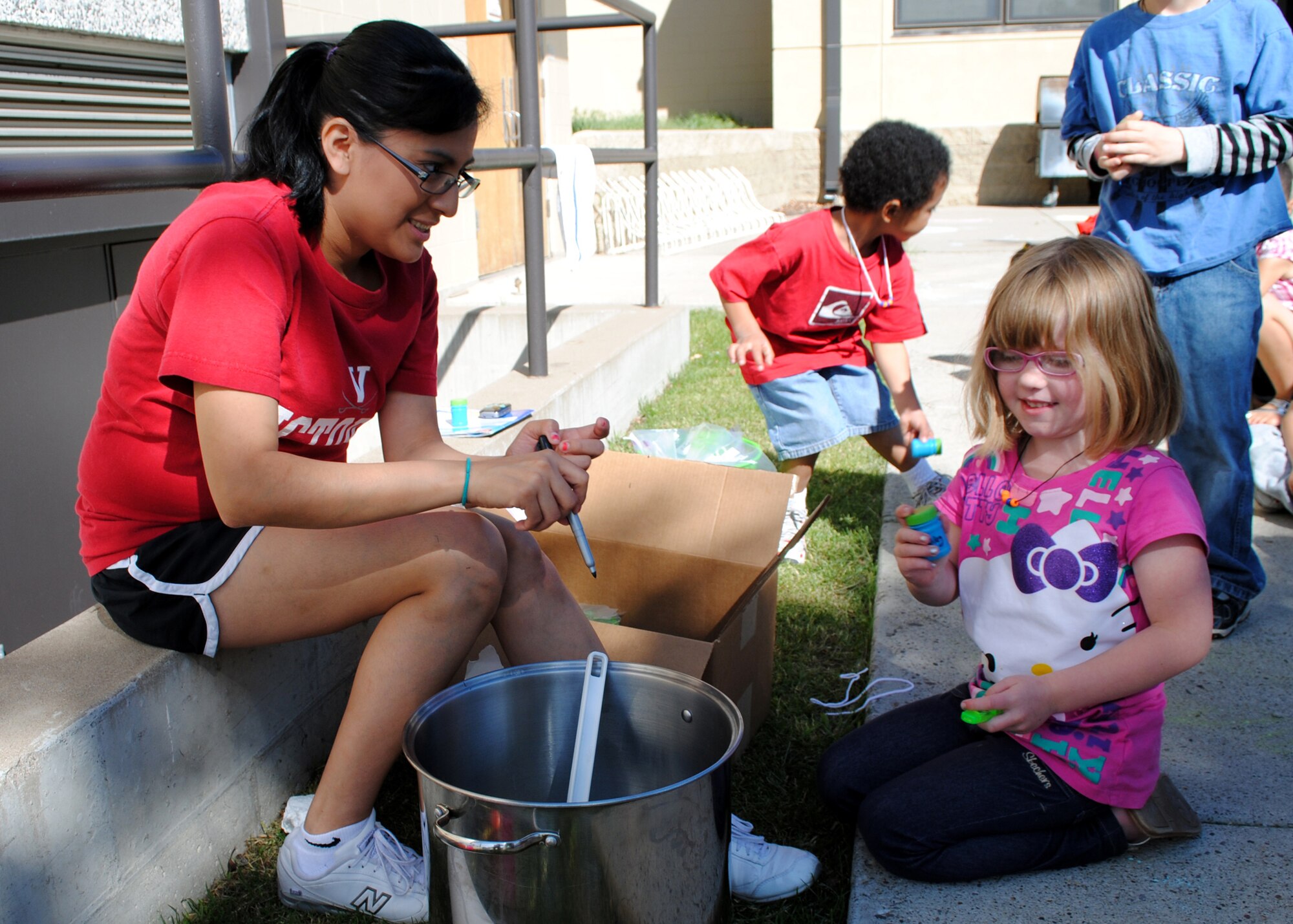 Marianna Ortiz, program volunteer (left), hands off a bottle of bubbles to Kailey Nowakoski, 6, during Malmstrom’s Vacation Bible School at the base chapel on June 15.  Children of Team Malmstrom and Fort Shaw Bible Church were taught a Bible lesson, played games and sang songs during the annual event.  (U.S. Air Force photo/Airman 1st Class Katrina Heikkinen)