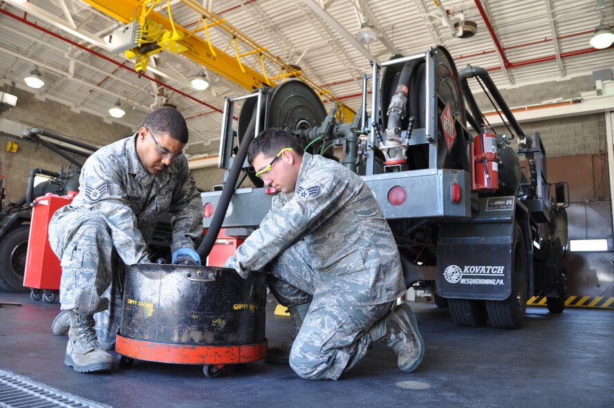 Staff Sgt. Ricky Anthony, 60th Logistics Readiness Squadron refueling maintenance supervisor, and Senior Airman Landon Sester, 60th LRS refueling maintenance technician, demonstrate how to drain fuel from an R-12 hydrant servicing vehicle Tuesday in the refueling maintenance shop. (U.S. Air Force photo/Staff Sgt. Patrick Harrower)