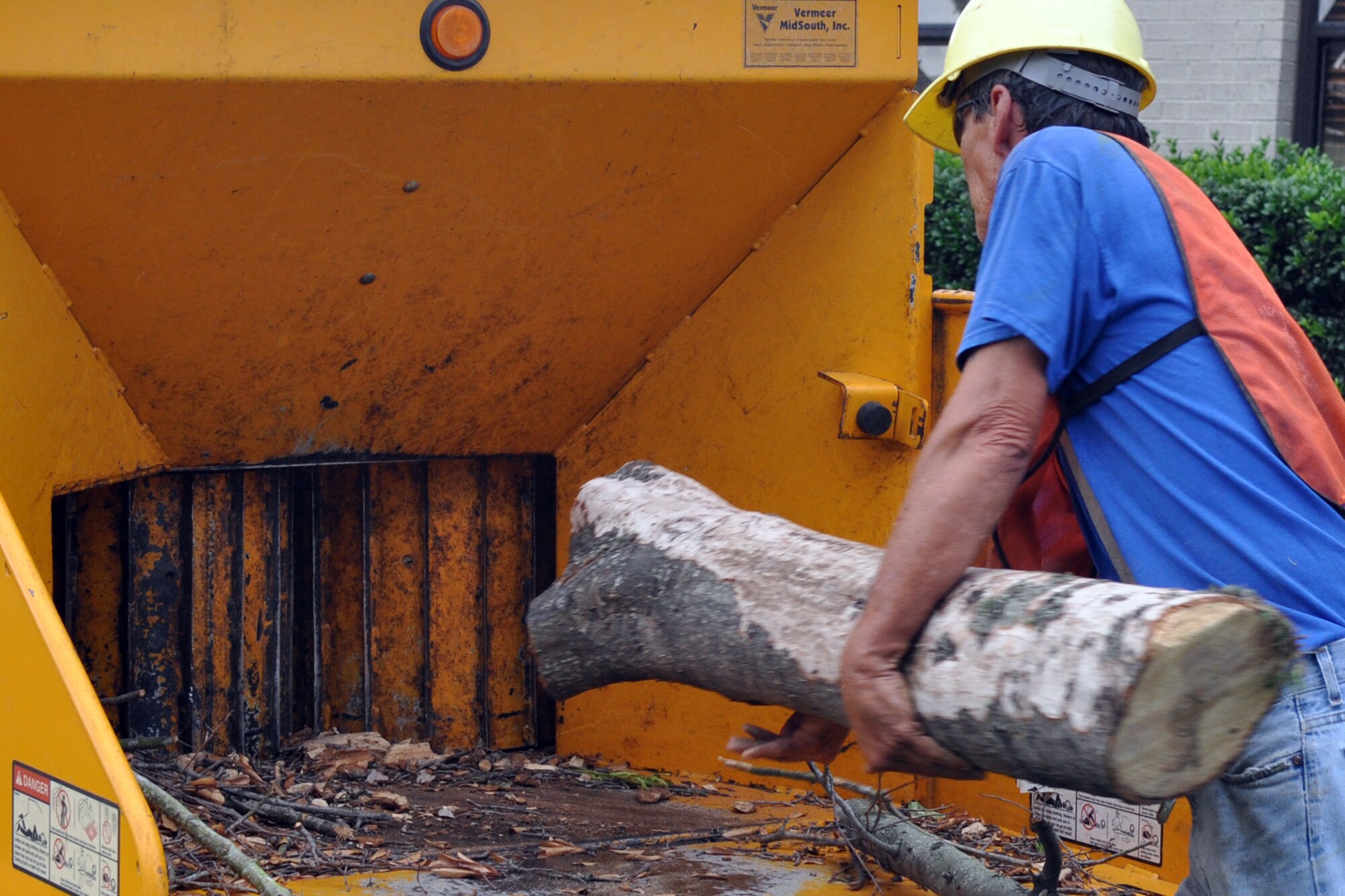 Tony Mead, a tree trimmer with Rushing Technical Services, Cabot Ark., prepares to chip a large portion of a dead tree he cut down at the 307th Bomb Wing Headquarters building on Barksdale Air Force Base, La., June 19, 2012. Due to the 2011 drought season and the warmest spring on record, hundreds of trees on Barksdale have died. Efforts are being made to clear the trees on the main base and in the housing areas. To date, workers for RTS have cleared approximately 30 trees off the main base. (U.S. Air Force photo by Master Sgt. Jeff Walston)  