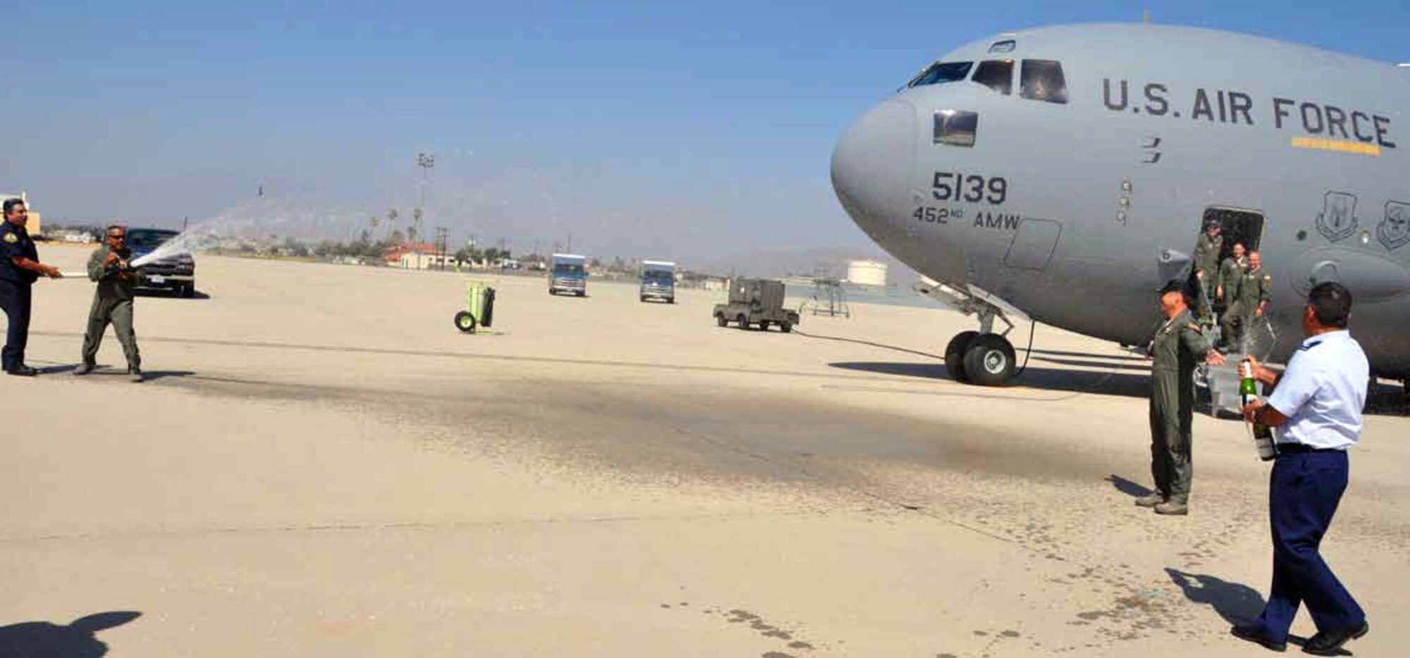 Lt. Col. Mark Larson, deputy commander, 452d Operational Support Squadron, returns from a TDY in Denmark to a hose down from the fire department and 729th Airlift Squadron personnel, as he completed his final flight piloting the C-17 Globemaster III, June 11. (U.S. Air Force photo by Staff Sgt. Megan Crusher)