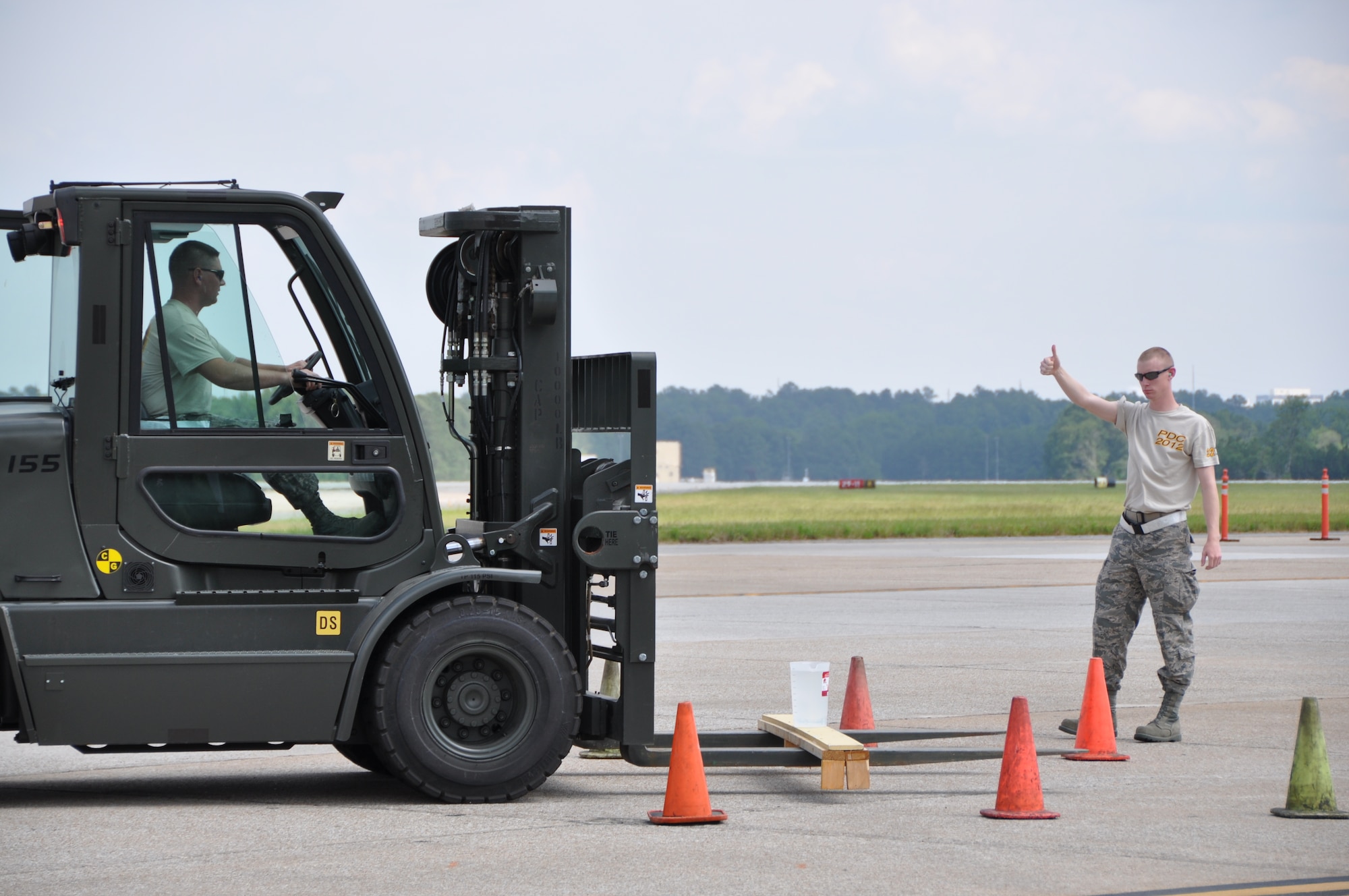 Tech. Sgt. Todd Losch Jr., 32nd Aerial Port Squadron air transportation specialist, delicately picks up a pitcher of water with a forklift after given the go ahead by his fellow teammate, Senior Airman Jonathan Hogan, during the three-day Port Dawg challenge held at Dobbins Air Reserve Base, Ga. The 10k relay race tested each unit on their skills to maneuver cargo in tight spaces and the correct use of “spotters” to give the driver accurate hand signals to help them complete the obstacle course. (U.S. Air Force photo by Tech. Sgt. Jamie L. Perry/Released)