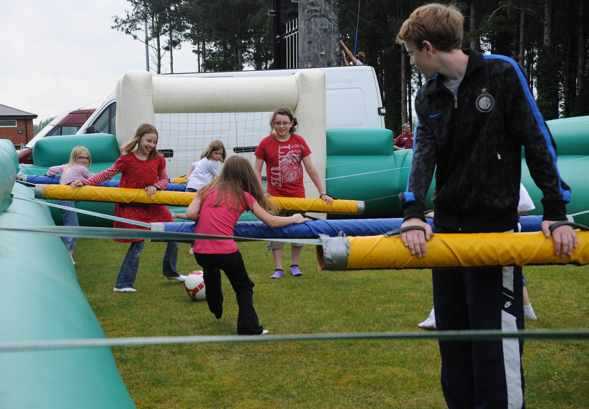 RAF MILDENHALL, England – Children participate in a game of giant foosball during the Team Mildenhall ‘Marauder Melee’ event at Heritage Park here June 21, 2012. Other family events included kids’ ‘Olympics,’ games, a wiggle kart and a mascot race between Sparky the Fire Dog and Max the Monkey. (U.S. Air Force photo/Toni Dineen)