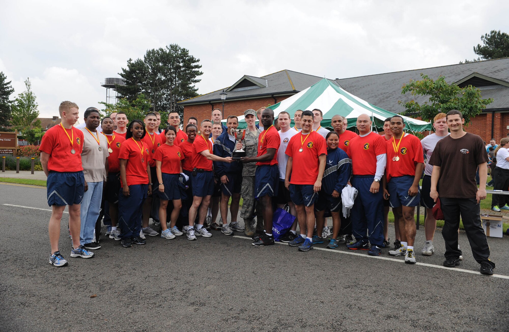 RAF MILDENHALL, England – Col. Christopher Kulas, 100th Air Refueling Wing commander, presents the ‘Marauder Melee’ championship cup to members of the 100th Communications Squadron at Heritage Park here June 21, 2012. The award was given to the squadron with the most participation and points earned throughout the day. (U.S. Air Force photo/Toni Dineen)