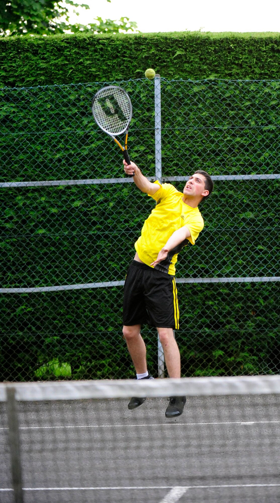 RAF MILDENHALL, England – Gregory Gavia, 100th Security Forces Squadron, serves during a tennis match that was part of the ‘Marauder Melee’ at RAF Mildenhall June 21, 2012. To round the day off, family-fun events were held for children, with activities such as a kids’ ‘Olympics,’ games, wiggle kart track, and a mascot race between Sparky the Fire Dog, Max the Monkey and others. (U.S. Air Force photo/Senior Airman Ethan Morgan)