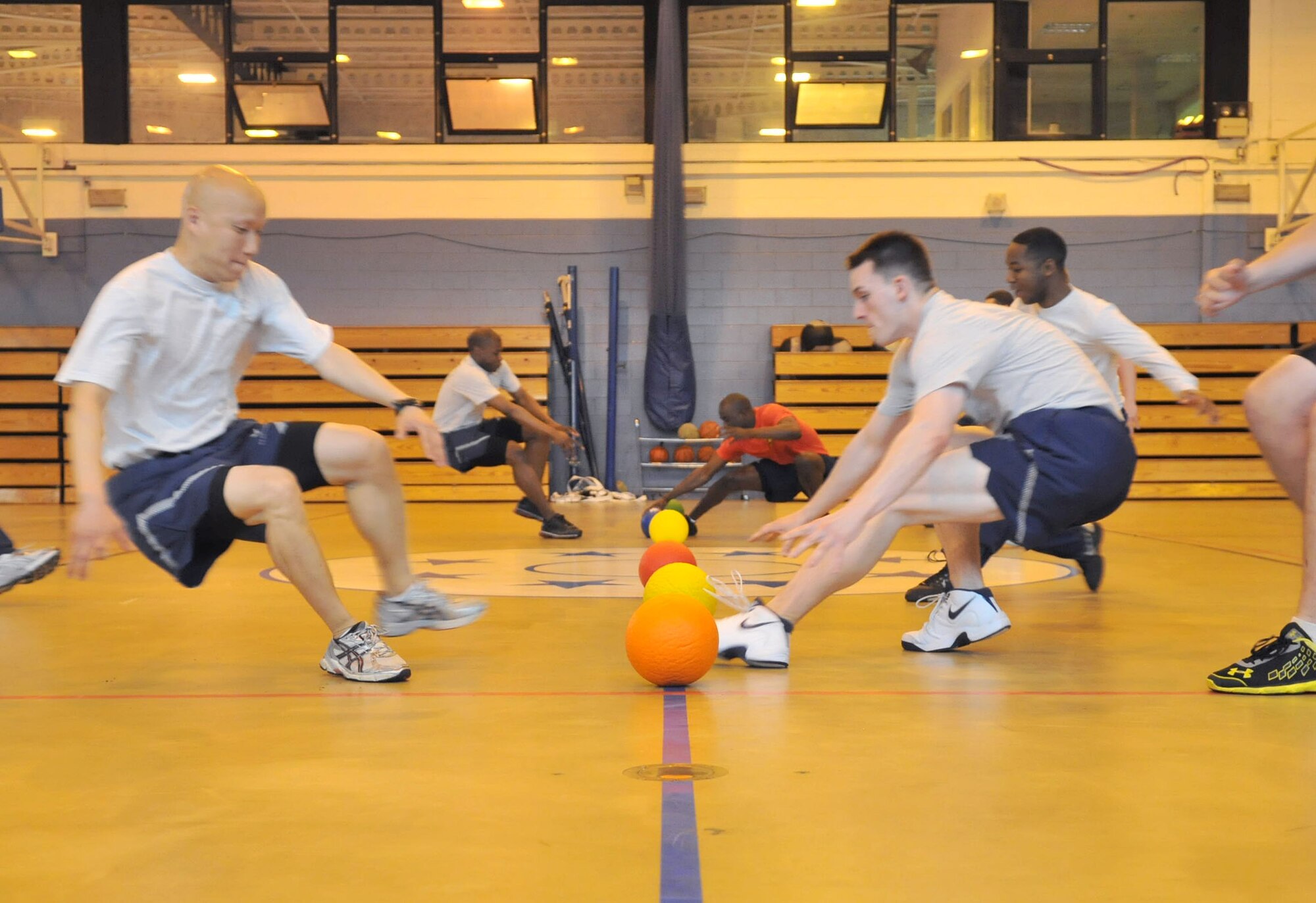 RAF MILDENHALL, England – Airmen from the 100th Operations Group (left) and the 100th Communications Squadron race for possession of the ball during a dodgeball challenge as part of the Marauder Melee event at the North Side Fitness Center here June 21, 2012. The challenge was one of one of several sporting events that took place throughout the base. Family-fun events such as kids’ ‘Olympics,’ games and a wiggle kart track were also held. (U.S. Air Force photo/Senior Airman Jerilyn Quintanilla)  