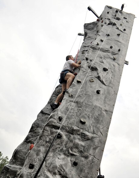 RAF MILDENHALL, England – Staff Sgt. Jessie Furse, 100th Civil Engineer Squadron, climbs the rock wall as part of the rock climbing challenge during the Marauder Melee event at Heritage Park here June 21, 2012. Other events took place throughout the base, including dodgeball, volleyball, a fitness challenge and an obstacle race. Family-fun events were held for children, with activities such as kids’ ‘Olympics,’ games and a wiggle kart track. (U.S. Air Force photo/Senior Airman Jerilyn Quintanilla)
