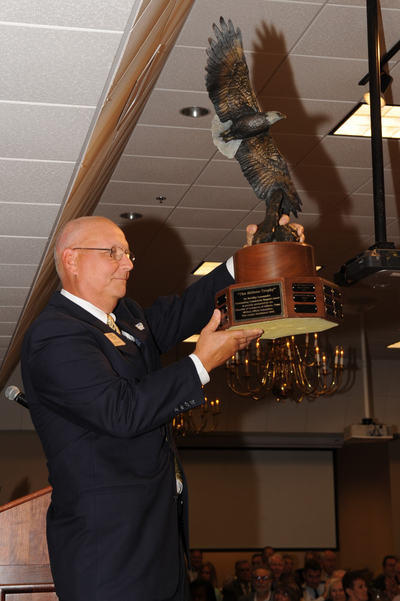 Mr. Larry Biernacki, Little Rock Air Force Base Community Council president, raises the 2011 Abilene Trophy during the general membership luncheon on June 20, 2012, at Little Rock Air Force Base, Ark. The Abilene Trophy is an award that is presented to the Air Mobility Command base with the best community support; Little Rock AFB Community Council received the award in 2009 and 2011. (RELEASED U.S. Air Force photo by Tech. Sgt. Chad Chisholm)
