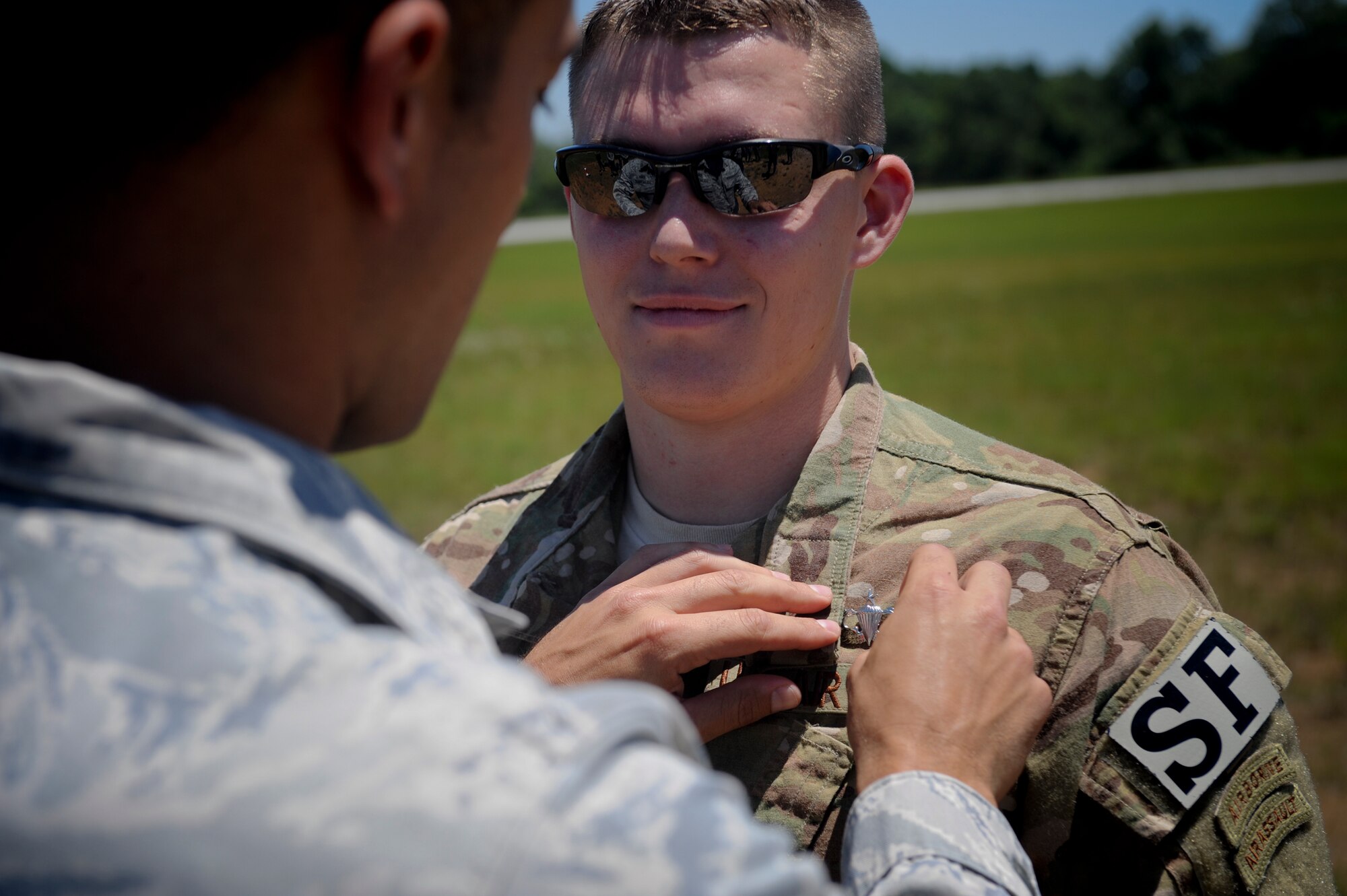 U.S. Air Force Senior Airman Derek Halverson, 824th Base Defense Squadron fire team member, receives his Senior Parachutist Badge from Tech. Sgt. David Edwards, 820th Combat Operations Squadron, at Henry Tift Myers Airport, Ga., June 19, 2012. Halverson earned the badge after completing all the requirements. (U.S. Air Force photo by Airman 1st Class Douglas Ellis/Released) 
