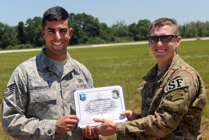 U.S. Air Force Senior Airman Derek Halverson, 824th Base Defense Squadron fire team member, receives his Senior Parachutist Badge from Tech. Sgt. David Edwards, 820th Combat Operations Squadron, at Henry Tift Myers Airport, Ga., June 19, 2012. To obtain the Senior Parachutist Badge, you must have a minimum of 30 jumps, 15 jumps with equipment, seven jumps as jumpmaster and at least two years on jump status. (U.S. Air Force photo by Airman 1st Class Douglas Ellis/Released) 
