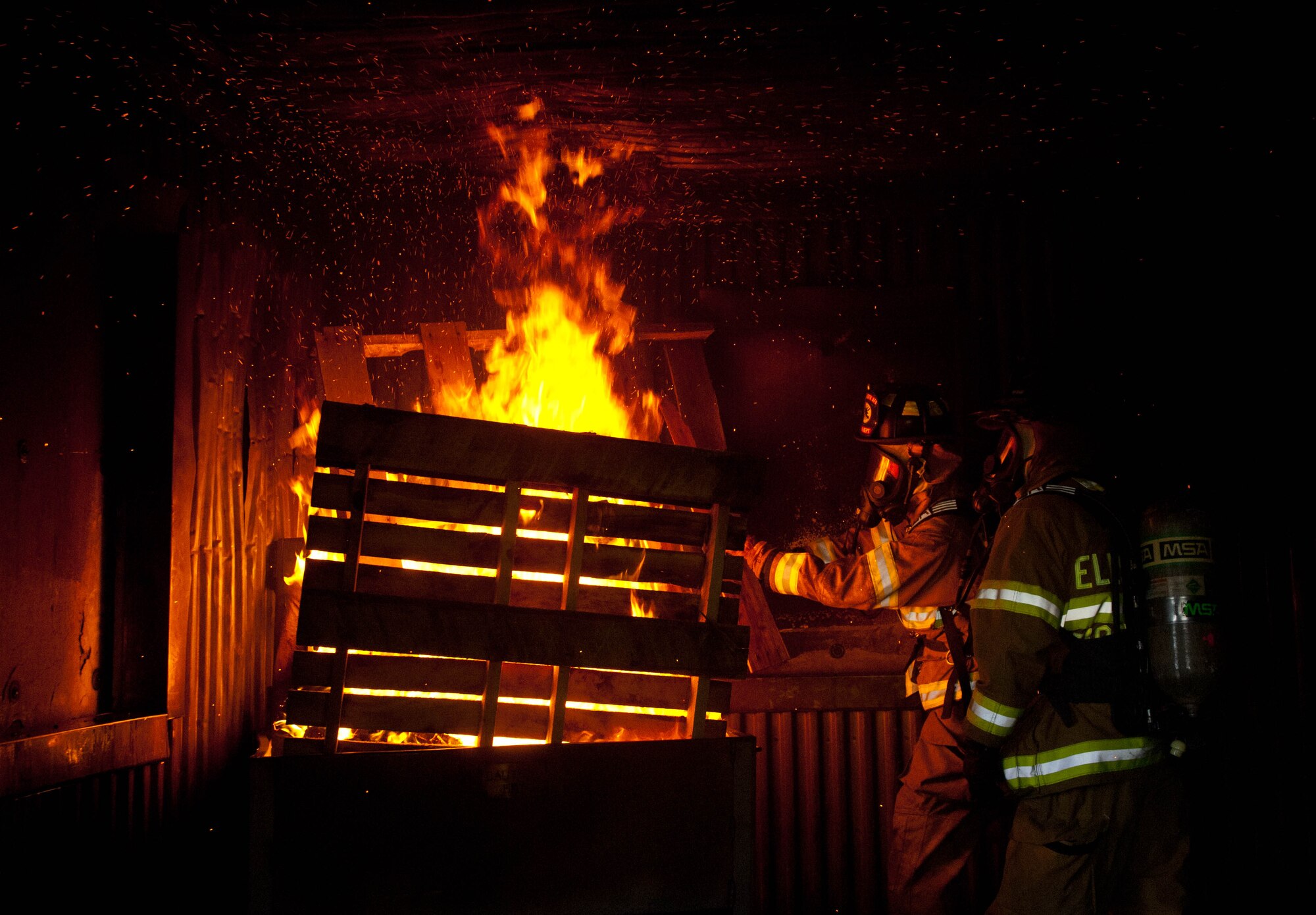 Airman 1st Class James Blair, and Bill Cina, 28th Civil Engineer Squadron fire protection specialists, prepare a simulated fire exercise at Ellsworth Air Force Base, S.D., June 18, 2012. The 28th CES fire department conducted joint exercises with Army National Guardsmen during the 2012 Golden Coyote exercise. (U.S. Air Force photo by Airman 1st Class Zachary Hada/Released)