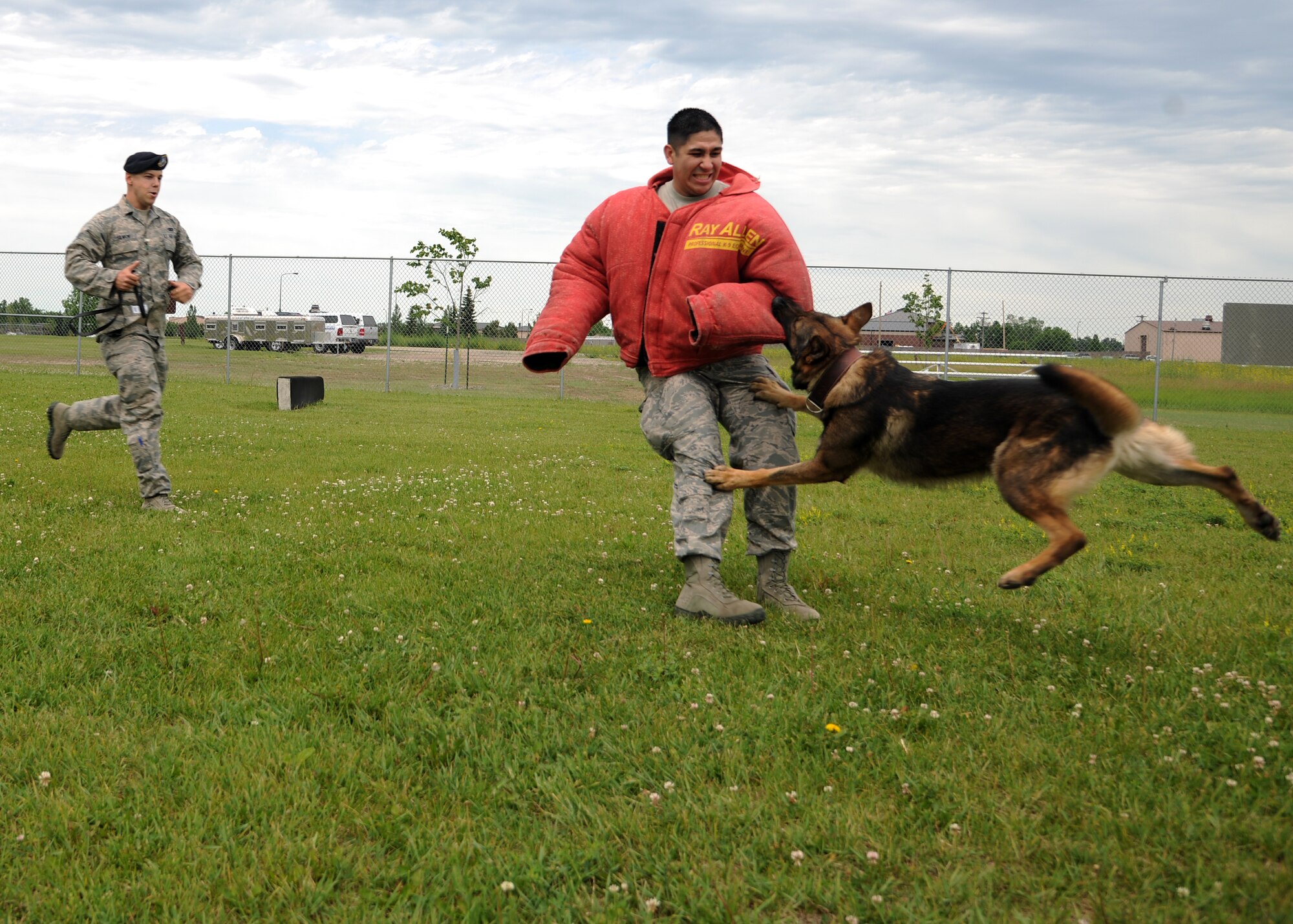 Senior Airman Brett Silmon, 319th Security Forces Squadron, chases down Senior Airman Joseph Schwochert, 319th SFS, during a training exercise with Atti, his military working dog, on June 19, 2012, on Grand Forks Air Force Base, N.D.  Silmon was named the latest Warrior of the Week for the 319th Air Base Wing. (U.S. Air Force photo/Airman 1st Class Ashley N. Taylor)