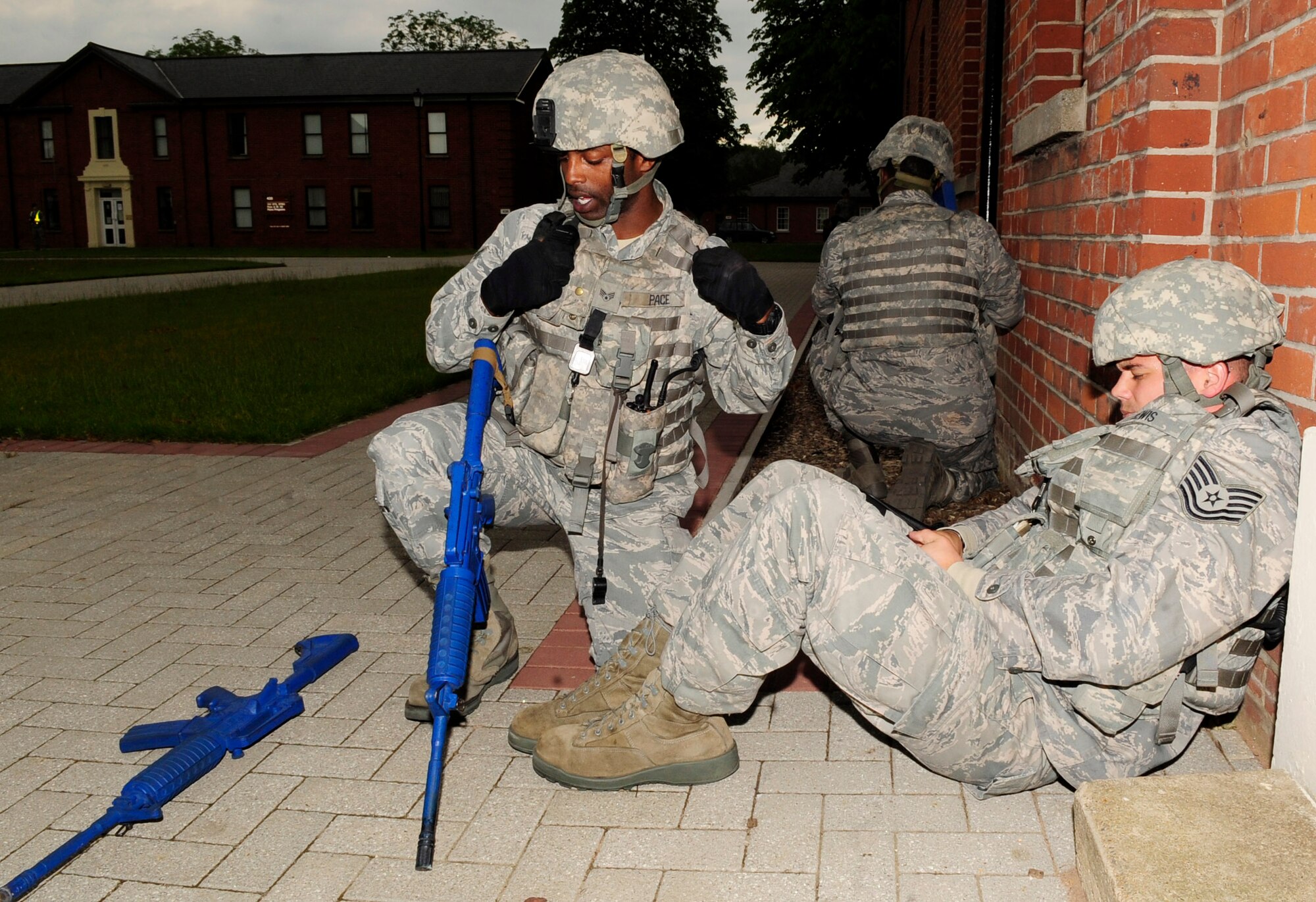 RAF MILDENHALL, England – Senior Airman Marcus Pace, (left) 100th Security Forces Squadron patrolman, calls in the status of the situation to the base defense operations center during an active shooter exercise held at RAF Mildenhall June 20, 2012. After reporting to the BDOC, Pace provided self-aid-buddy-care to Tech. Sgt. Joshua Lewis, (right) 100th SFS, after he sustained a simulated gun-shot wound during the exercise. (U.S. Air Force photo/ Senior Airman Ethan Morgan)