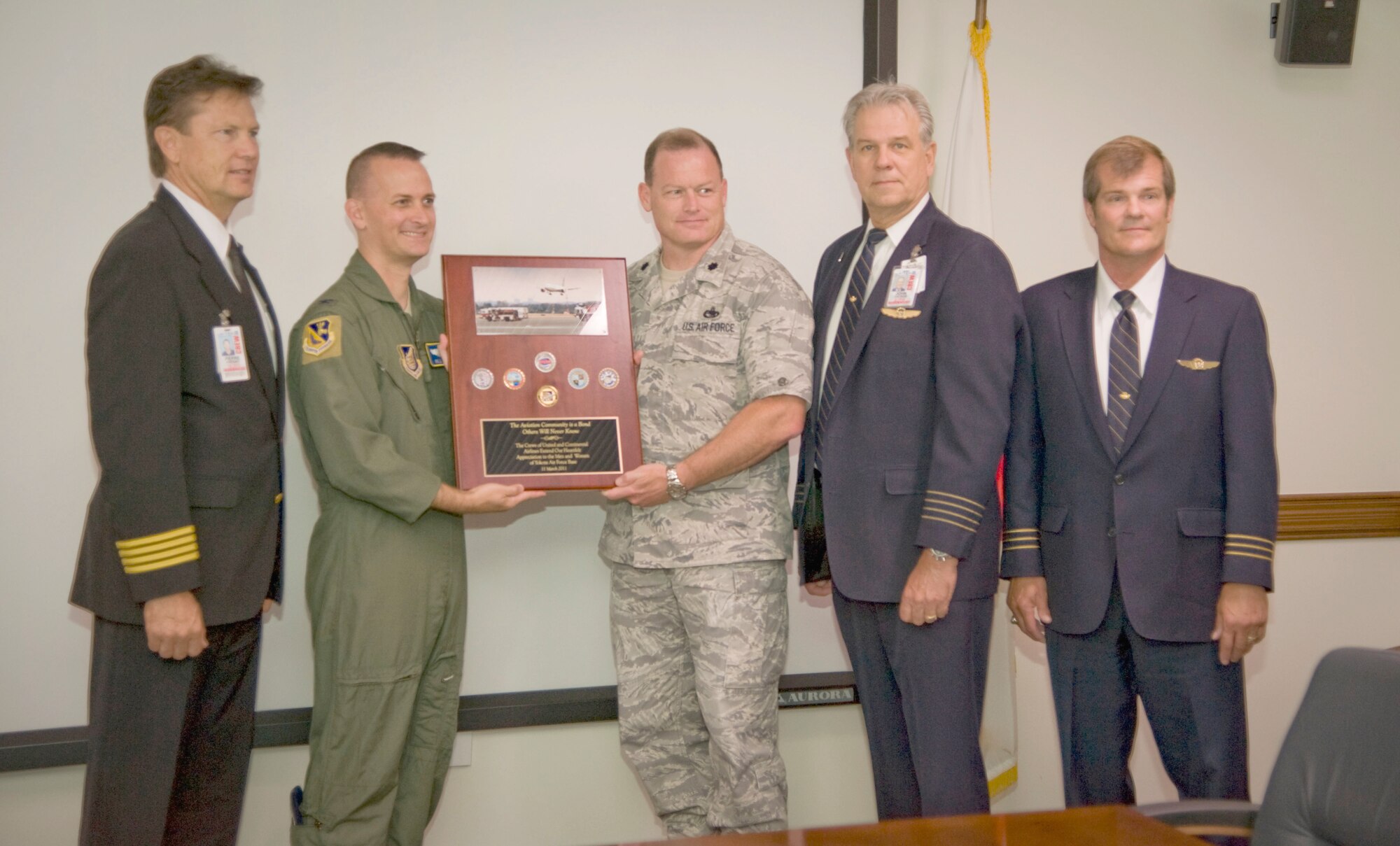 YOKOTA AIR BASE, Japan -- Three pilots from both Continental and United Airlines visited with wing leadership at Yokota Air Base, Japan, on June 21, 2012 to present a token of thanks for the assistance the base provided to the airlines during Operation Tomadachi in 2011. (Left to right) Chief Pilot Pierre Frenay, United Airlines, Guam, pose for a photo with Col. Bill Knight, 374th Airlift Wing commander, Lt. Col. Robert Neal, 730th Air Mobility Squadron commander, Capt. Johnny Yackus, live standards manager for Boeing 007, United Airlines, and First Officer Charles Schneiss, Boeing 007, United Airlines. (U.S. Air Force photo by Staff Sgt. Shawn Rhodes)