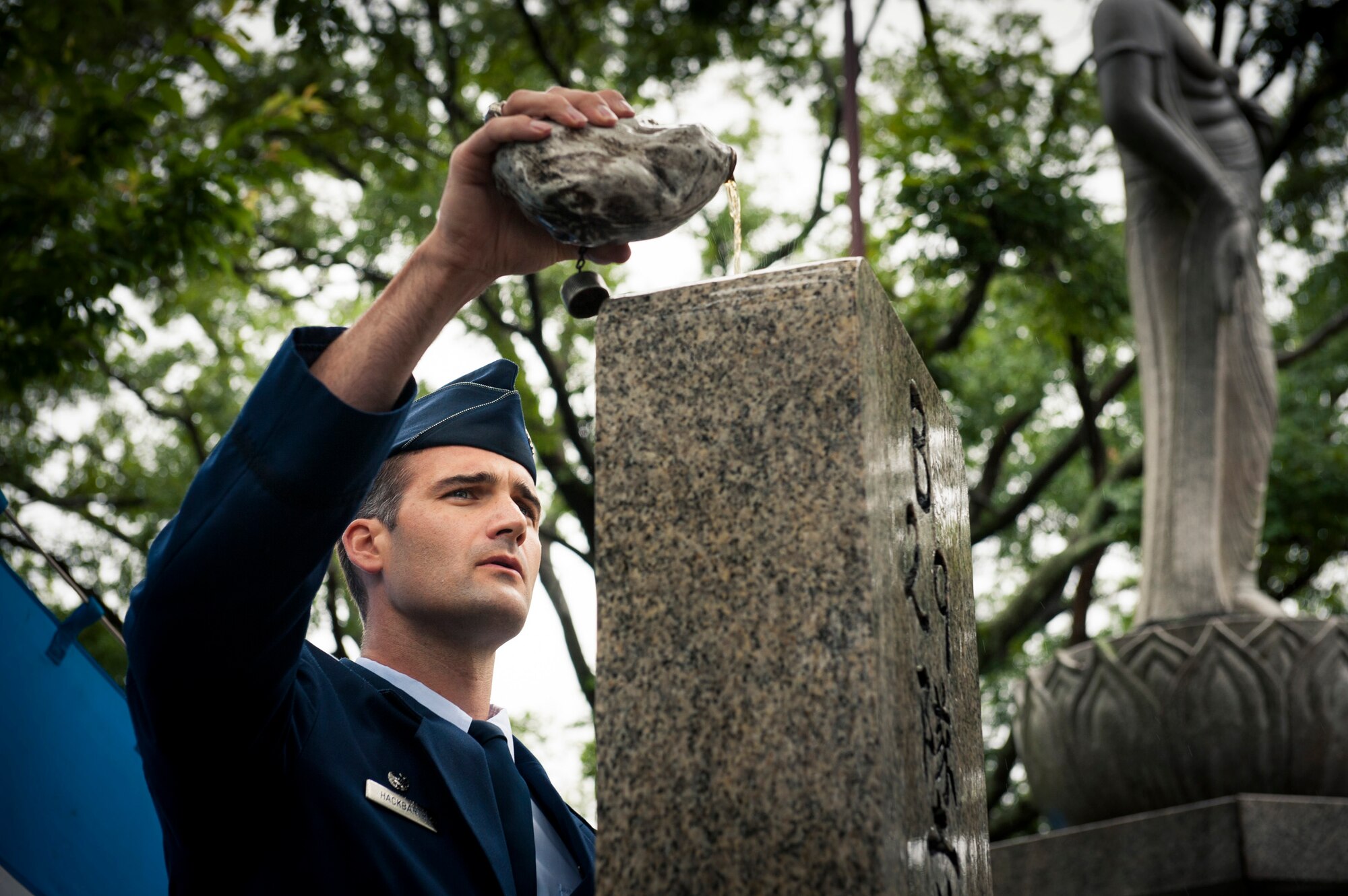 SHIZUOKA, Japan -- Lt. Col. James Hackbarth, 374th Operations Support Squadron commander, pours bourbon from World War II-era canteen over an American monument on Mount Shizuhata, Shizuoka, Japan, June 16, 2012. The canteen was found, warped and deformed, at the crash site of two B-29 bombers after they collided mid-air during a bombing raid over Shizuoka. (U.S. Air Force photo by Tech. Sgt. Samuel Morse)