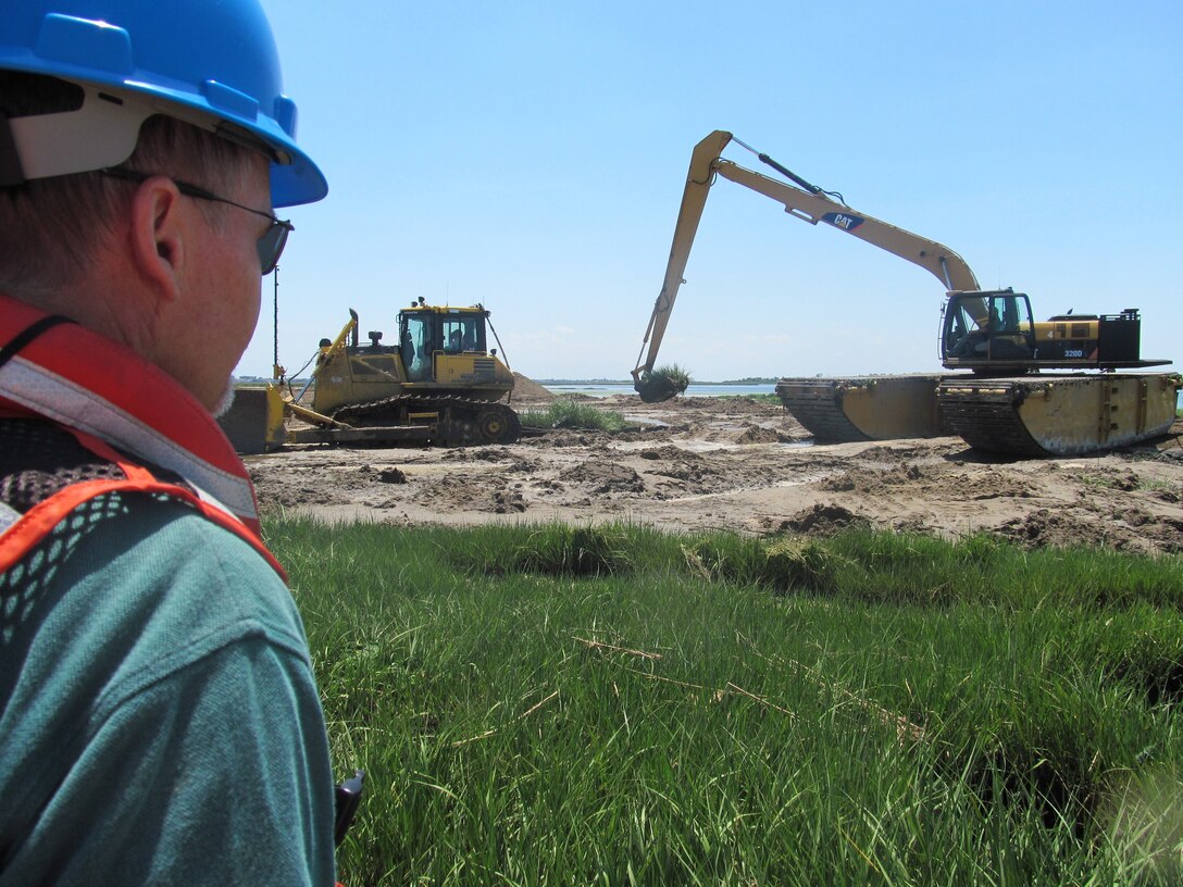 NEW YORK — Project Stakeholder from the New York State Department of Environmental Conservation watches hummock removal process.


