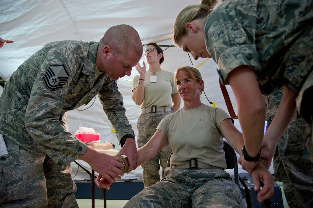 Air Force medical personnel demonstrate how to apply restraints to a simulated patient during Exercise Global Medic on Fort Hunter Liggett, Calif., June 17, 2012.