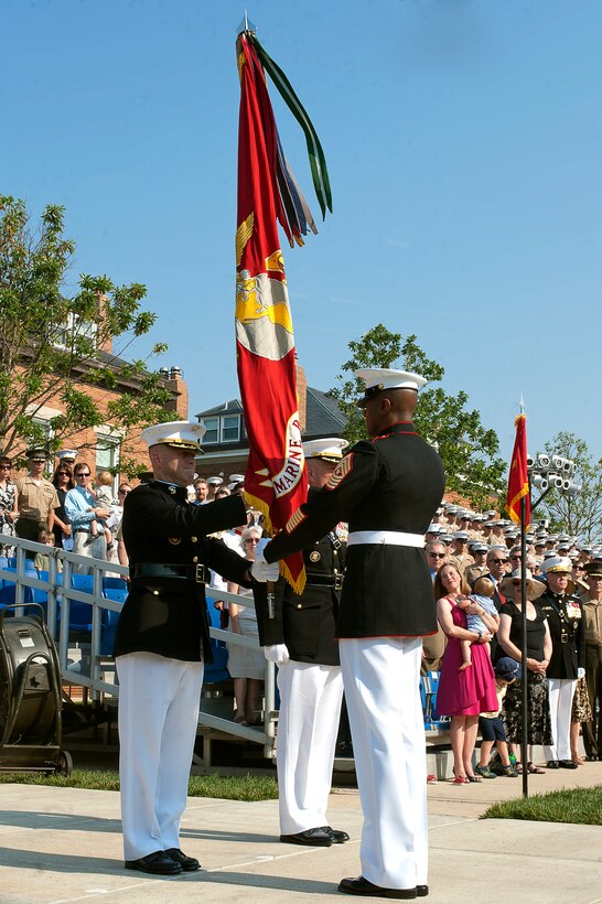 Col. Paul D. Montanus, commanding officer of Marine Barracks Washington, takes the command colors from SgtMaj. Eric Stockton, Barracks sergeant major, during a change of command ceremony here June 21. Montanus relinquished command of the oldest post of the Corps to Col. Christian Cabaniss.