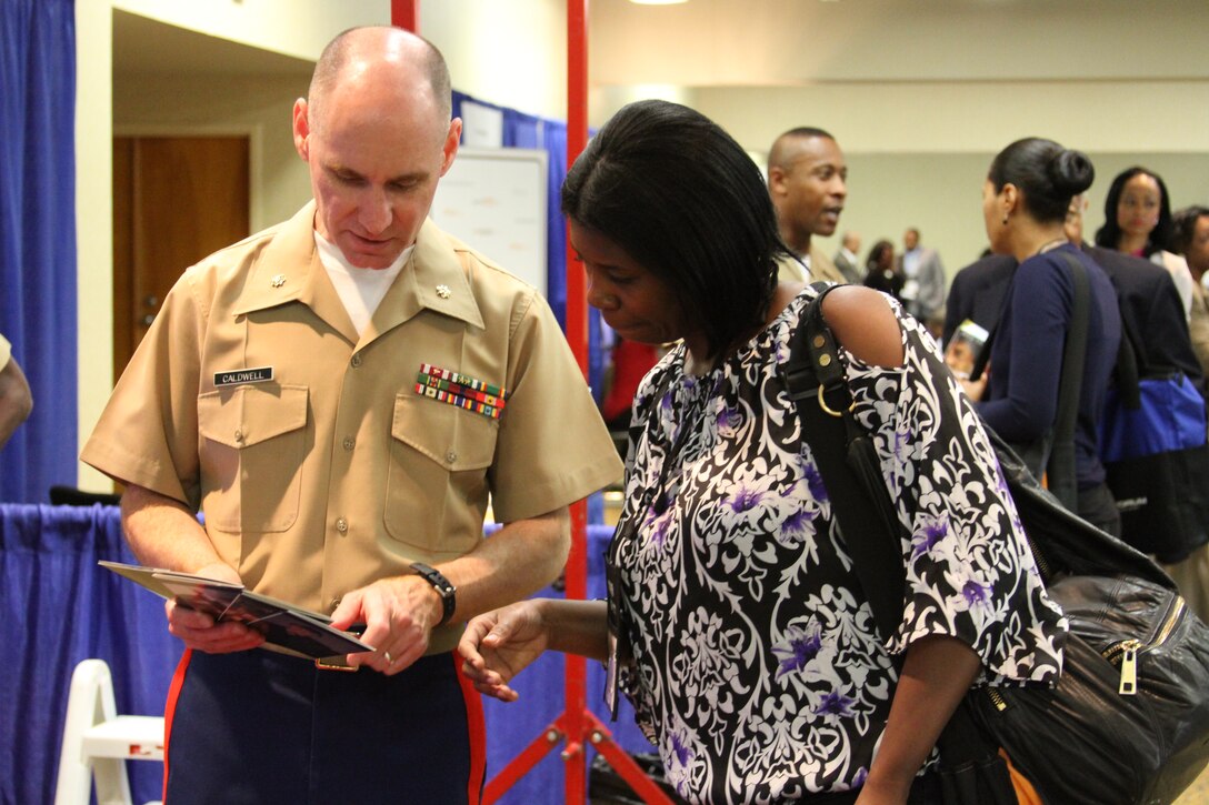 Major John Caldwell, national director, public affairs, Marine Corps Recruiting Command, goes over information on Marine Corps scholarships with an attendee of the National Association of Black Journalists convention.::r::::n::::r::::n::::r::::n::