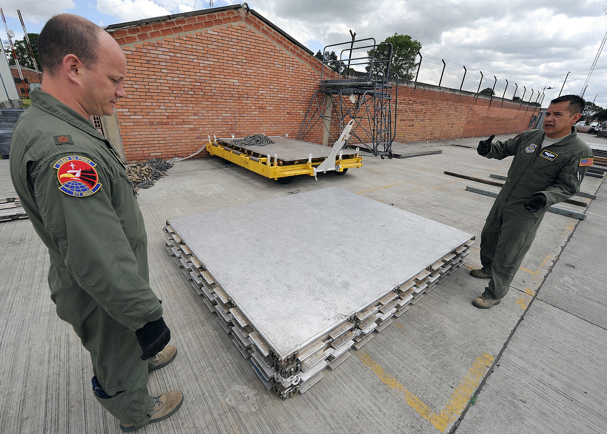Staff Sgt. Javier Borges (right), 571st Mobility Support Advisory Squadron loadmaster air advisor explains  pallet ring serviceability to Maj. Brian Symon, 571st MSAS Colombia mission commander, during an Air Mobility Command Building Partner Capacity mission June 20 at Commando Aéreo de Transporte Militar, Bogota, Colombia.  The 571st is participating in a month-long BPC mission with the Colombian air force to promote regional stability by fostering key relationships and enhancing partner nation capabilities.  The mission also supports the 12th Air Force’s (AFSOUTH) continued engagements in the U.S. Southern Command area of responsibility of Latin America and the Caribbean.  In addition, the 571st reached out to Inter-American Air Forces Academy and 12th AF (AFSOUTH) for assistance to complement their team. (U.S. Air Force photo by Tech. Sgt. Lesley Waters)