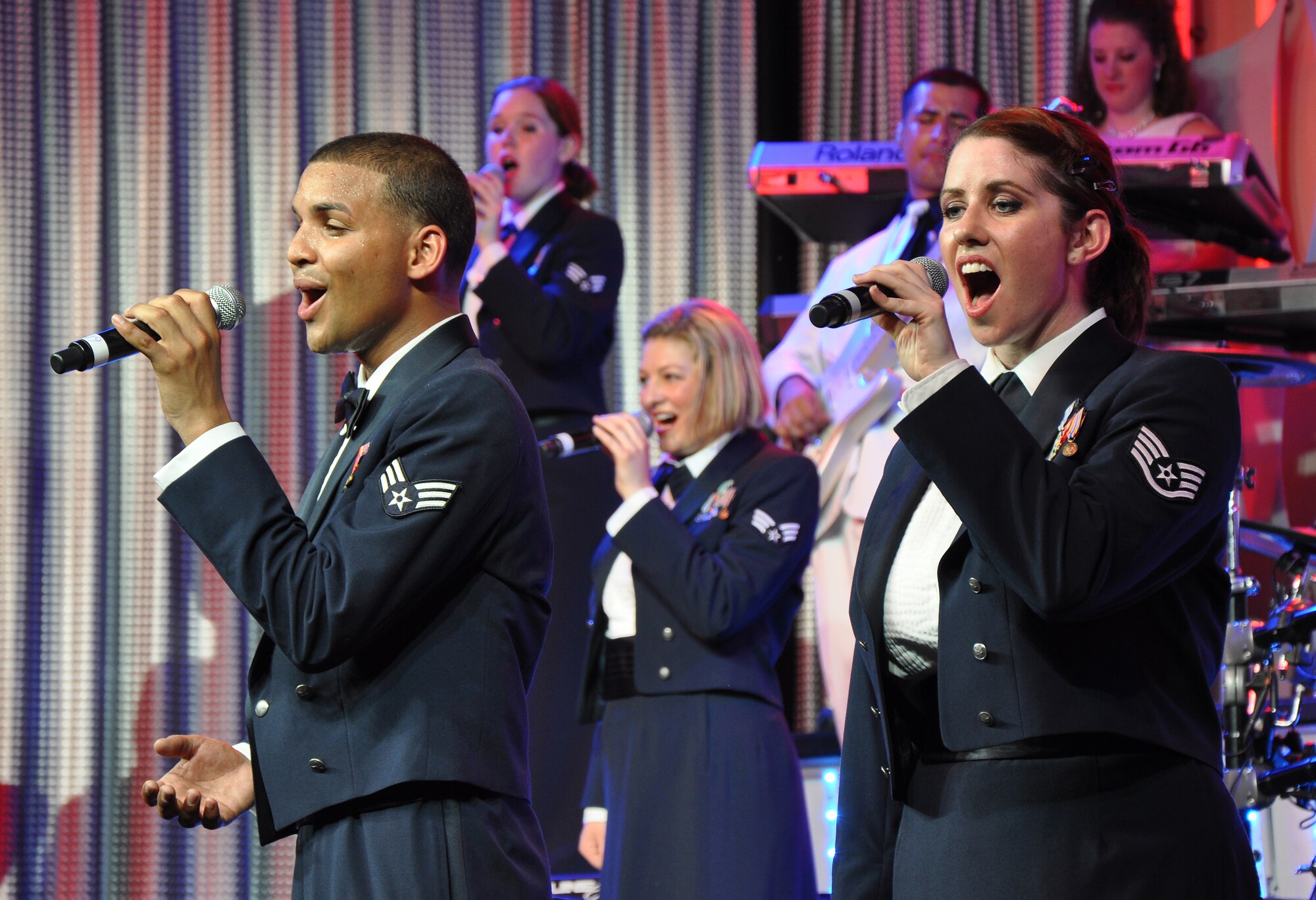 Senior Airman Emmanuel Maldonado Rosario and Staff Sgt. Robin Elrod, Tops in Blue Vocalists, sing at Beale Air Force Base, Calif., June 16, 2012. TIB is composed of 35 to 40 vocalists, musicians, dancers, and technicians. (U.S. Air Force photo by Staff Sgt. Robert M. Trujillo/Released)