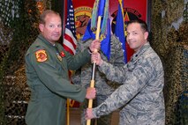 Col. Daniel Tippett, 57th Adversary Tactics Group commander, passes the 527th Space Agressor Squadron guidon to the incoming commander, Lt. Col. Scott Bonzer, during a change of command ceremony here June 22. (U.S. Air Force photo/Bill Evans)