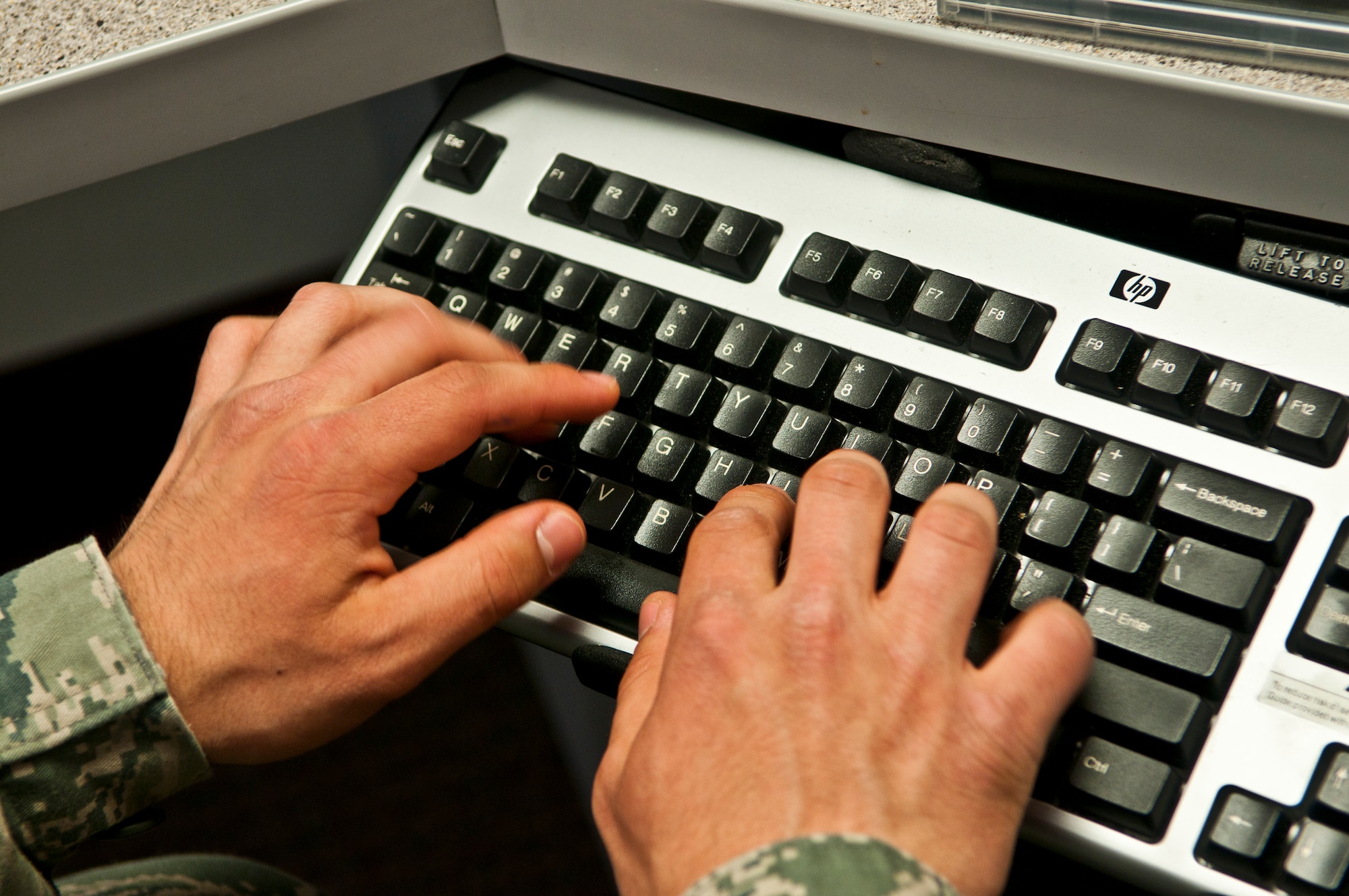 Airman 1st Class Cal Szur, 90th Communications Squadron client systems technician, types on a keyboard while installing a program on the computer of a 90th CS client in the 20th Air Force Headquarters building June 19. (U.S. Air Force Photo by Airman 1st Class Jason Wiese)