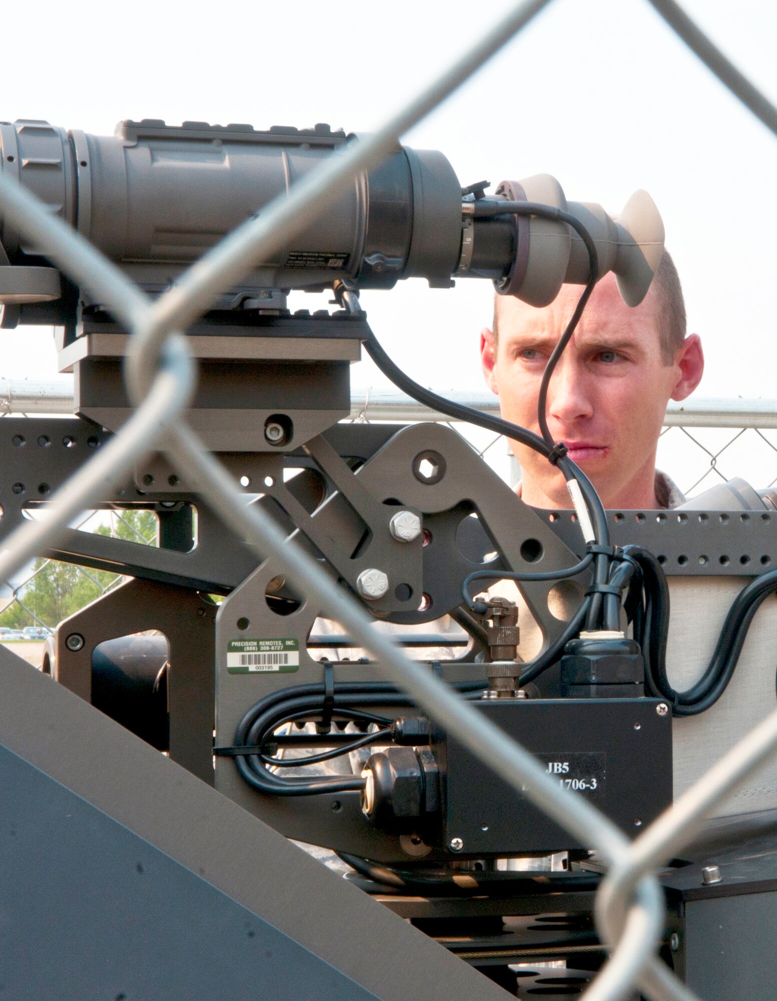 Staff Sgt. Ryan Nelson, 90th Communications Squadron Visual Imagery and Intrusion Detection Systems non-commissioned officer in charge,  gives movement commands to a technician performing an operational check on the Remote Targeting Engagement System outside of Building 1250 June 18. (U.S. Air Force Photo by Airman 1st Class Jason Wiese)