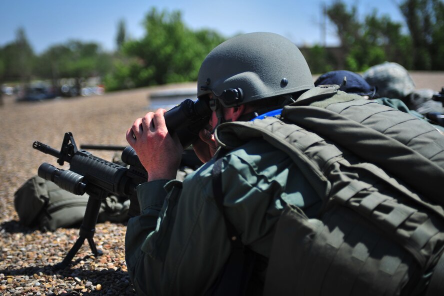 A member of the Clovis, N.M., Police Departments Special Weapons And Tactics team gets a better view of the scene near a simulated gunman situation in front of the Courthouse at Cannon Air Force Base, N.M., June 20, 2012. Cannon teamed up with Clovis Police Department during the exercise to diffuse the scenario. (U.S. Air Force photo by Airman 1st Class Alexxis Pons Abascal) 