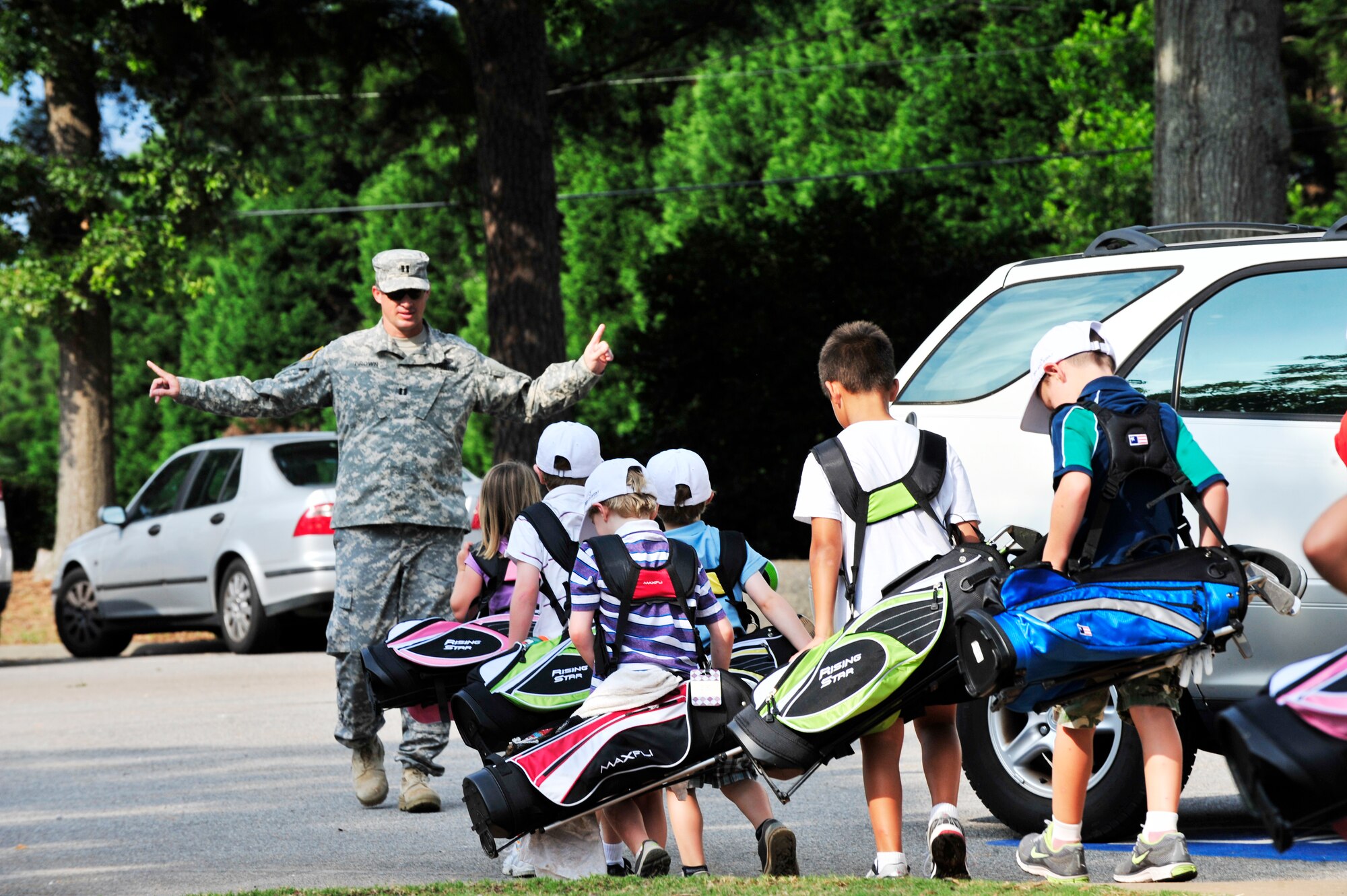 U.S. Army Capt. Jeremy Brown, Third Army/ARCENT, special troops battalion logistics officer, marches students to the next station during the Air Combat Command kids’ golf program at the Carolina Lakes Golf Course, Shaw Air Force Base, S.C., June 20, 2012.  This four-day class started on June 18. The class was organized by Katharine Williams, Carolina Lakes director of golf and former Professional Golf Association professional.(U.S. Air Force Airman Nicole Sikorski/Released)
