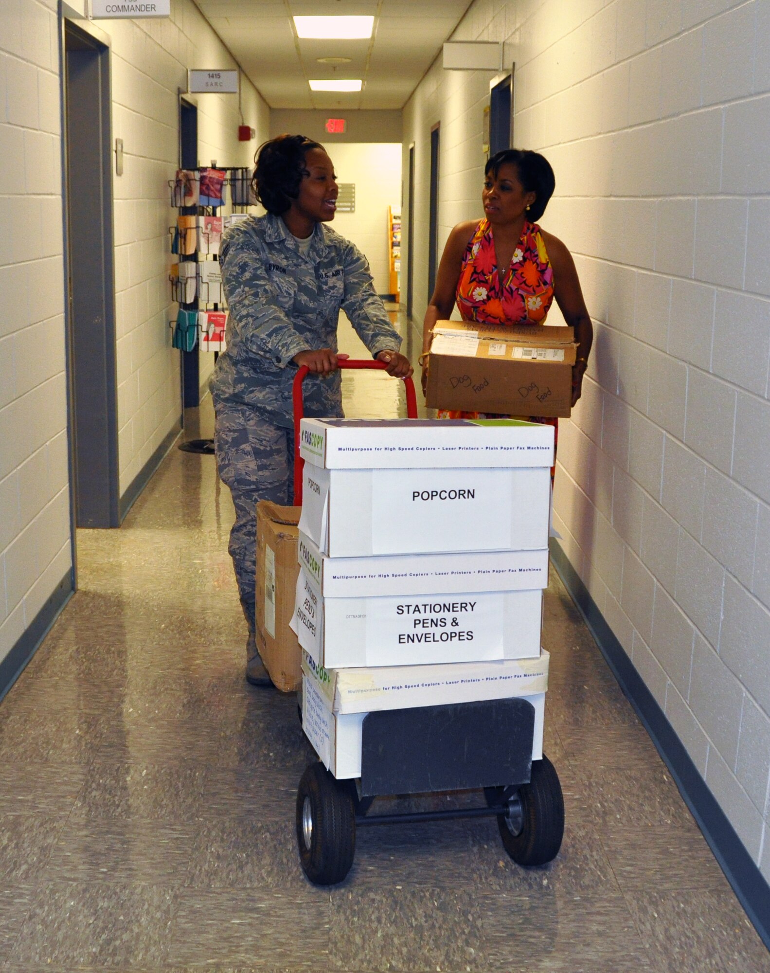 Senior Airman Tumyra D. Byron, Airman and Family Readiness administrative assistant, and Angela Pederson, Airman and Family Readiness Office director, prepare for Family Care Package Day by sorting and moving items that families will have available to send to their deployed Airmen. Family Care Package Day will be held June 30 from 9 a.m. to 1 p.m. in Verhulst Hall, building 813 at Dobbins Air Reserve Base. (U.S. Air Force photo/Senior Airman Elizabeth Gaston)