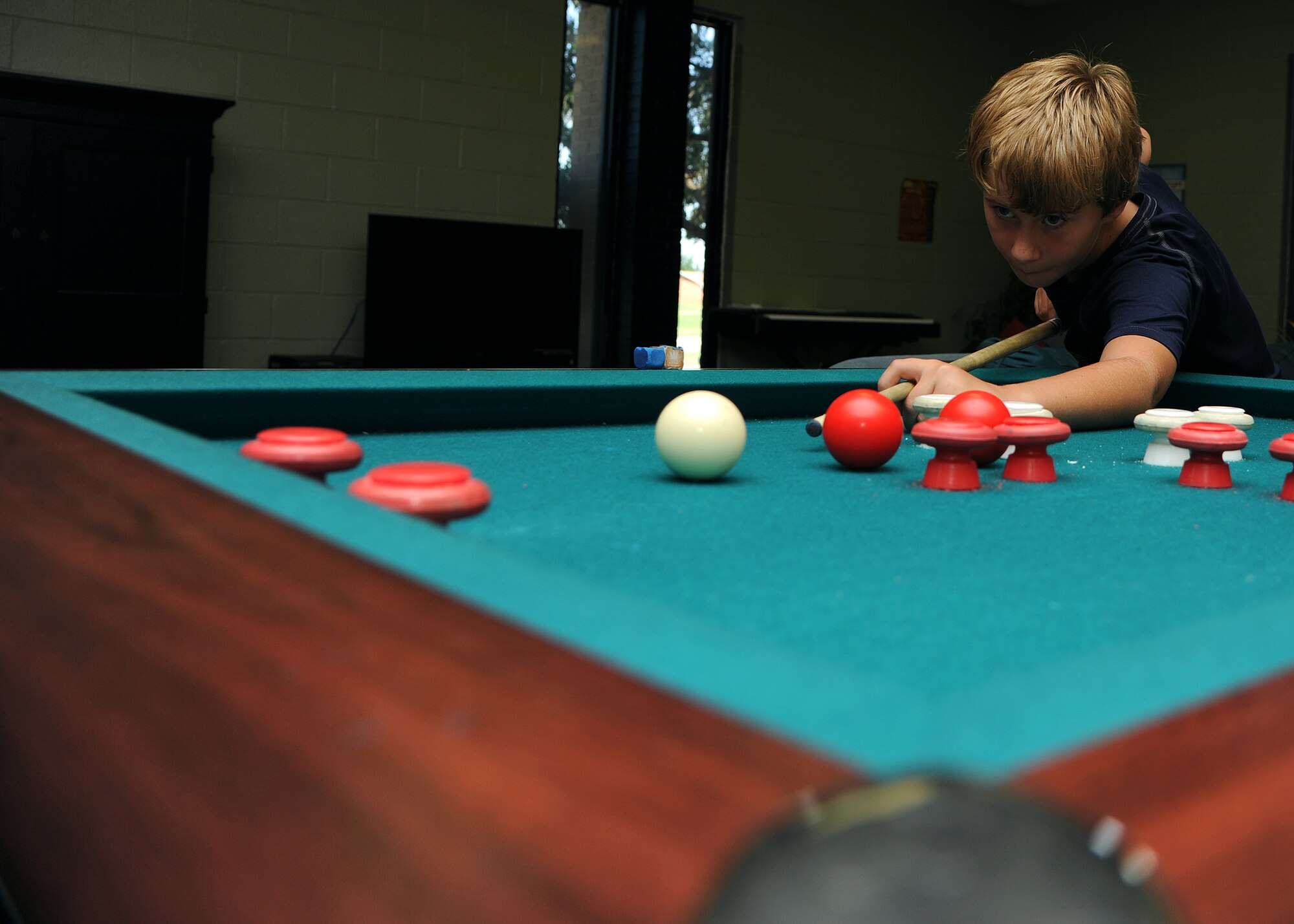 ALTUS AIR FORCE BASE, Okla. – Brennan Clements plays bumper pool at the base Youth Center June 19, 2012. The new summer Open Recreation program is available weekdays from 8:30 a.m. to 2 p.m. for children ages 9 to 18-years-old. The standard school-age program is available weekdays from 2 p.m. to 6 p.m. (U.S. Air Force photo by Airman Klynne Pearl Serrano / 97th Air Mobility Wing Public Affairs / Released)