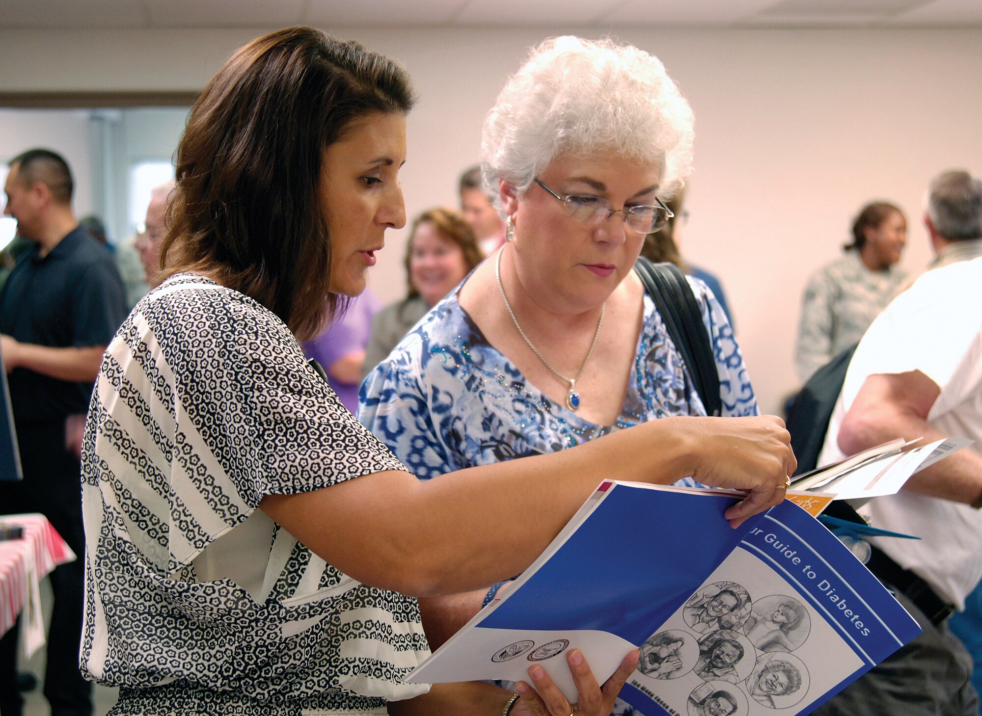 Tinker nurse health manager Valerie Gauthier, left, discusses a booklet on health tips with Alice Beine, from Jenks, during the June 15 Tinker Military Retiree Appreciation Day.  Mrs. Beine’s husband served in the Navy and Army National Guard. (Air Force photo by Margo Wright)