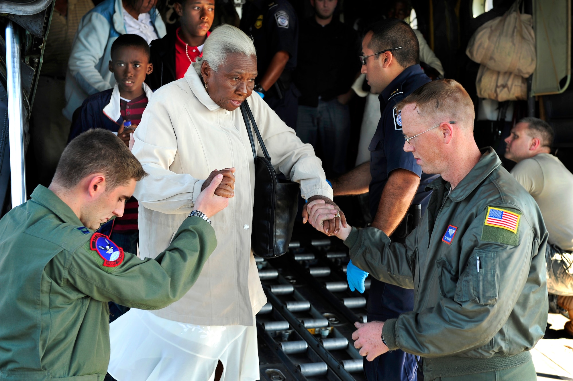 Capt. Philip Noland, left, and Tech. Sgt. Brian Ghent help an elderly Haitian earthquake survivor down the ramp of a C-130 Hercules aircraft at Homestead Air Reserve Base, Fla., Jan. 20, 2010. (U.S. Air Force photo/Staff Sgt. Greg C. Biondo)