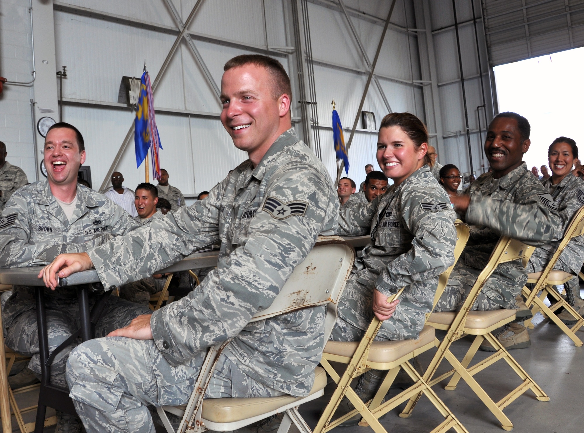 Members of the80th Aerial Port Squadron Port Dawg Challenge team share a laugh as they watch another team perform their skit as penance for losing their Dawg bone.  Dobbins Air Reserve Base hosted the Air Force Reserve Command Port Dawg Challenge June 19-21. (U.S. Air Force photo/Senior Airman Elizabeth Gaston)