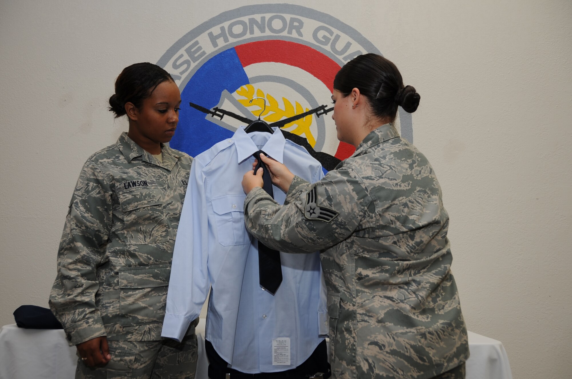 JOINT BASE PEARL HARBOR-HICKAM, Hawaii – Airman 1st Class Ciera Lawson holds a uniform while Senior Airman Agelle Ponsetti, 442nd Force Support Squadron, adjusts the tie, June 20, 2012. Lawson and Ponsetti are preparing the uniform to accompany the deceased remains of a veteran recovered from overseas. Lawson and Ponsetti are on temporary duty working and training in various positions within the mortuary affairs office here. The 442nd Force Support Squadron is part of the 442nd Fighter Wing, an A-10 Thunderbolt II Air Force Reserve unit at Whiteman Air Force Base, Mo. (U.S. Air Force photo/Staff Sgt. Lauren Padden)