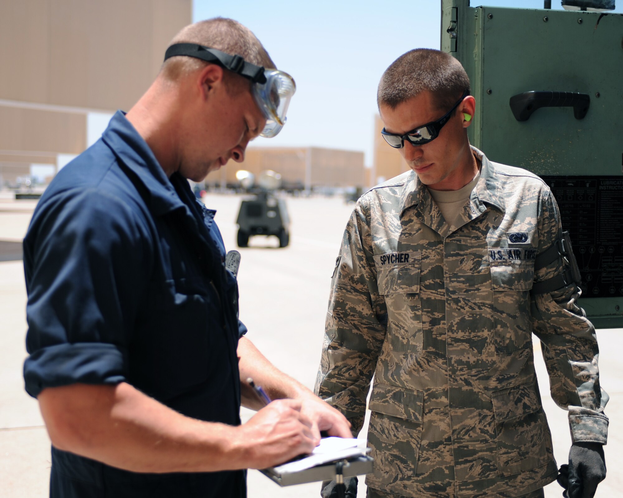 U.S. Air Force Staff Sgt. Timothy Stacy, 355th Aircraft Maintenance Squadron, signs off Airman 1st Class Justin Spycher, 355th Logistics Readiness Squadron, on Davis-Monthan Air Force Base, Ariz., June 21, 2012. (U.S. Air Force photo by Airman 1st Class Christine Griffiths/Released) 