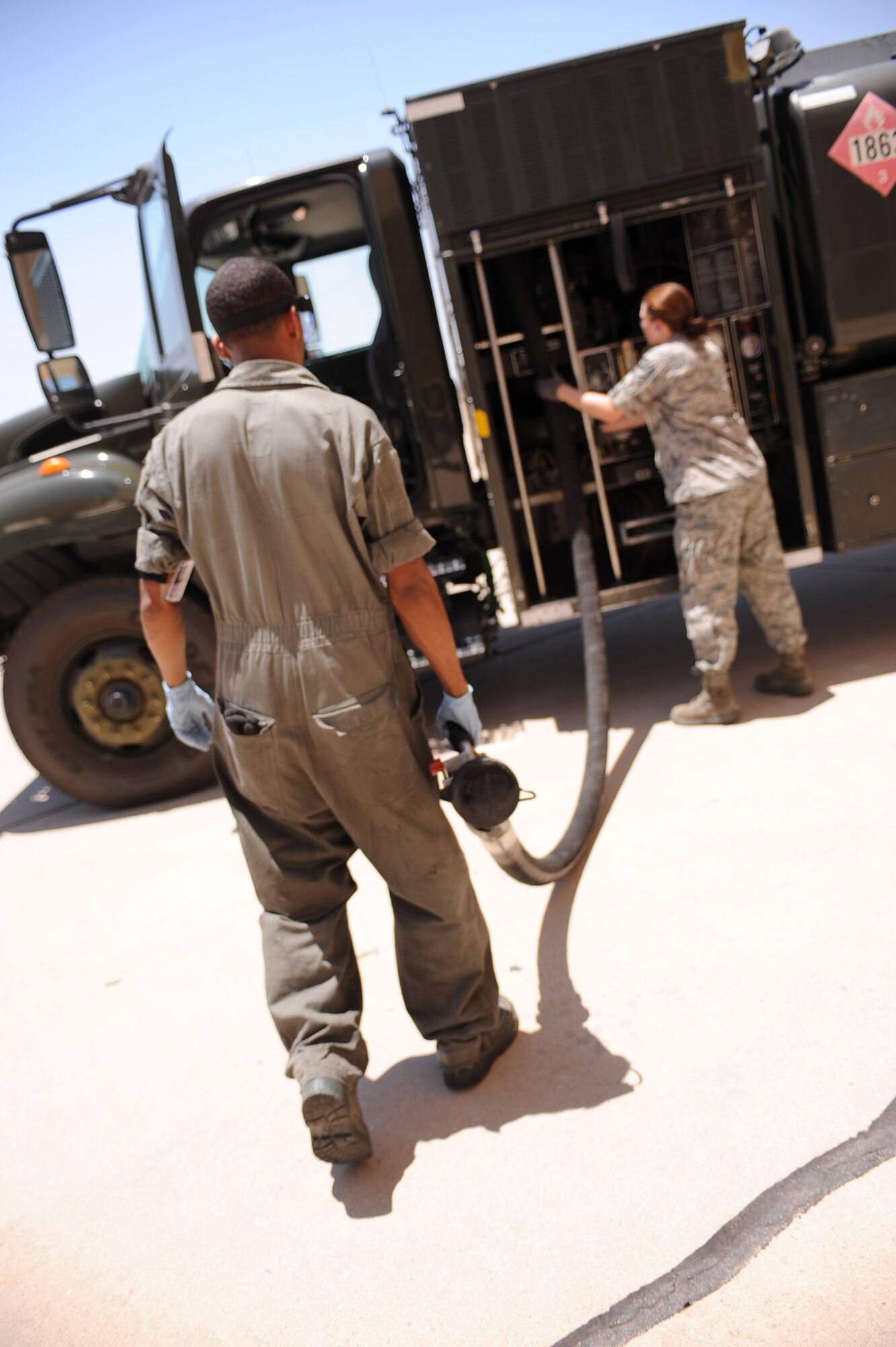 U.S. Air Force Airman 1st Class Samuel Cox, 355th Aircraft Maintenance Squadron, and Airman 1st Class Kaitlin Carroll, 355th Logistics Readiness Squadron, retract the refueling hose back into the R-11 fuel truck on Davis-Monthan Air Force Base, Ariz., June 21, 2012. Davis-Monthans fuels shop has 12 trucks; 11 for refueling aircraft and 1 for the defueling of aircraft. (U.S. Air Force photo by Airman 1st Class Christine Griffiths/Released) 