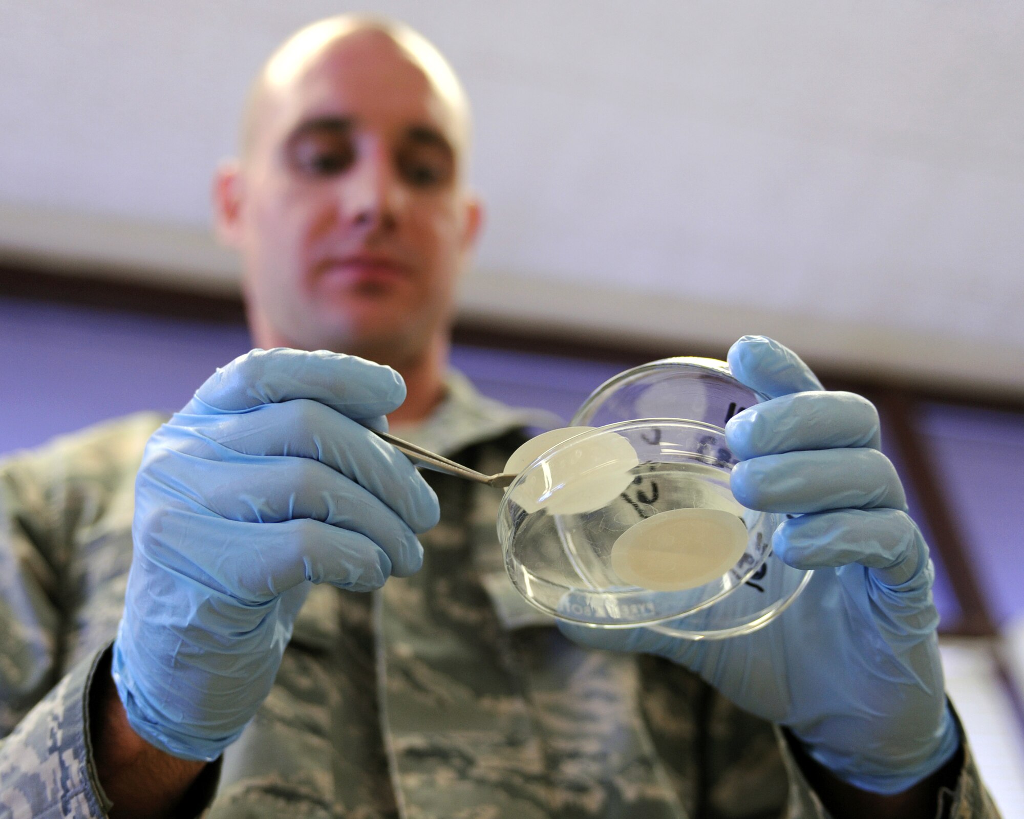 U.S. Air Force Tech. Sgt. Select Clark Twiss, 355th Logistics Readiness Squadron, examines gasoline filter paper samples at the fuels lab on Davis-Monthan Air Force Base, Ariz., June 21, 2012. Gas is filtered to check for dirt of any that may be in it; The cleaner fuels are needed to keep the fuselage clean for better performance. (U.S. Air Force photo by Airman 1st Class Christine Griffiths/Released) 