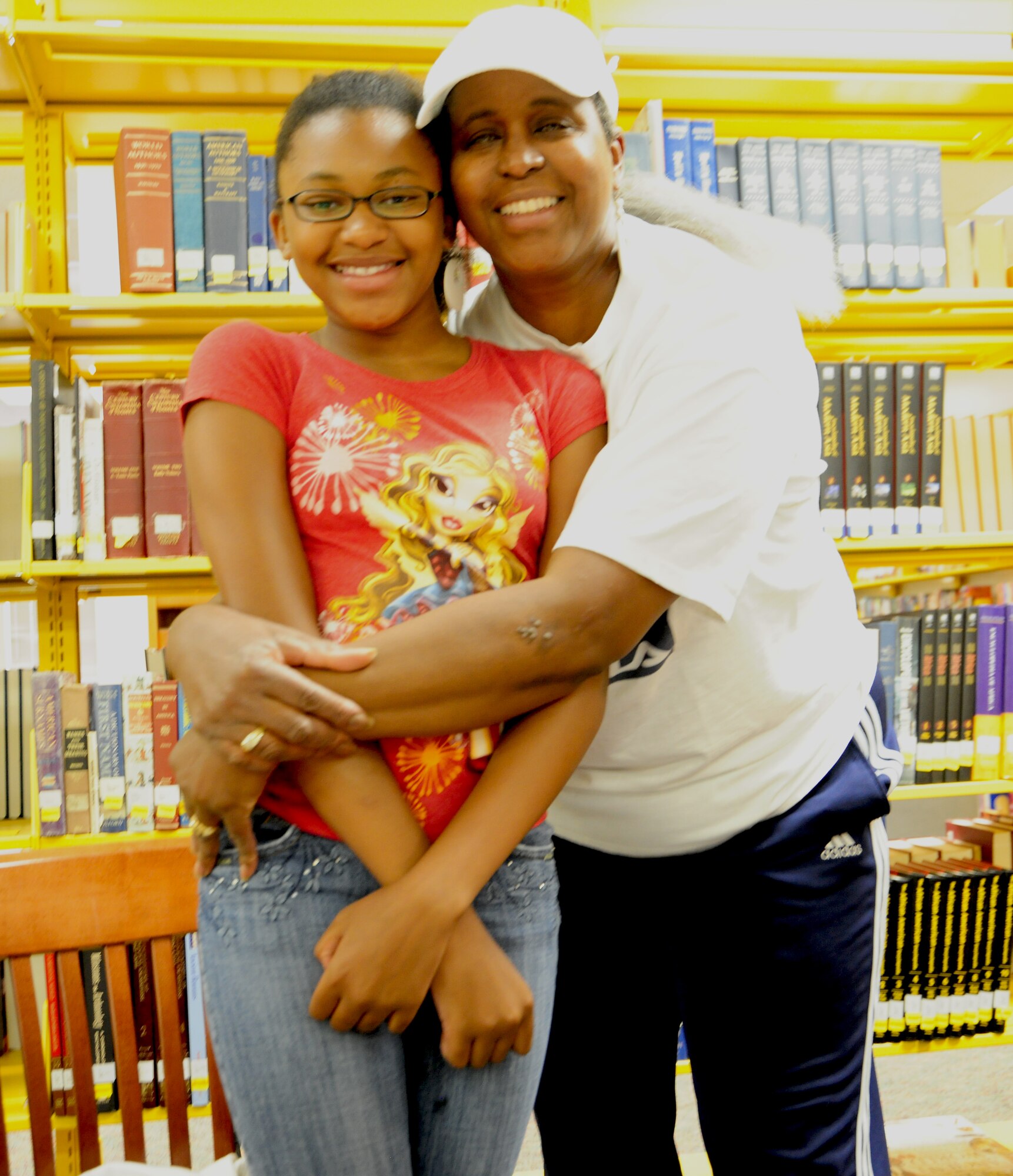 Donna Moore, Air Force retiree, embraces her daughter Jazymn Brown Washington during opening day of the Summer Reading program at the library at Joint Base Andrews Library on June 18. The Summer Reading program motivates, inspires and teaches individuals of all ages to read as much as possible. (U.S. Air Force Photo/Senior Airman Amber Russell)
