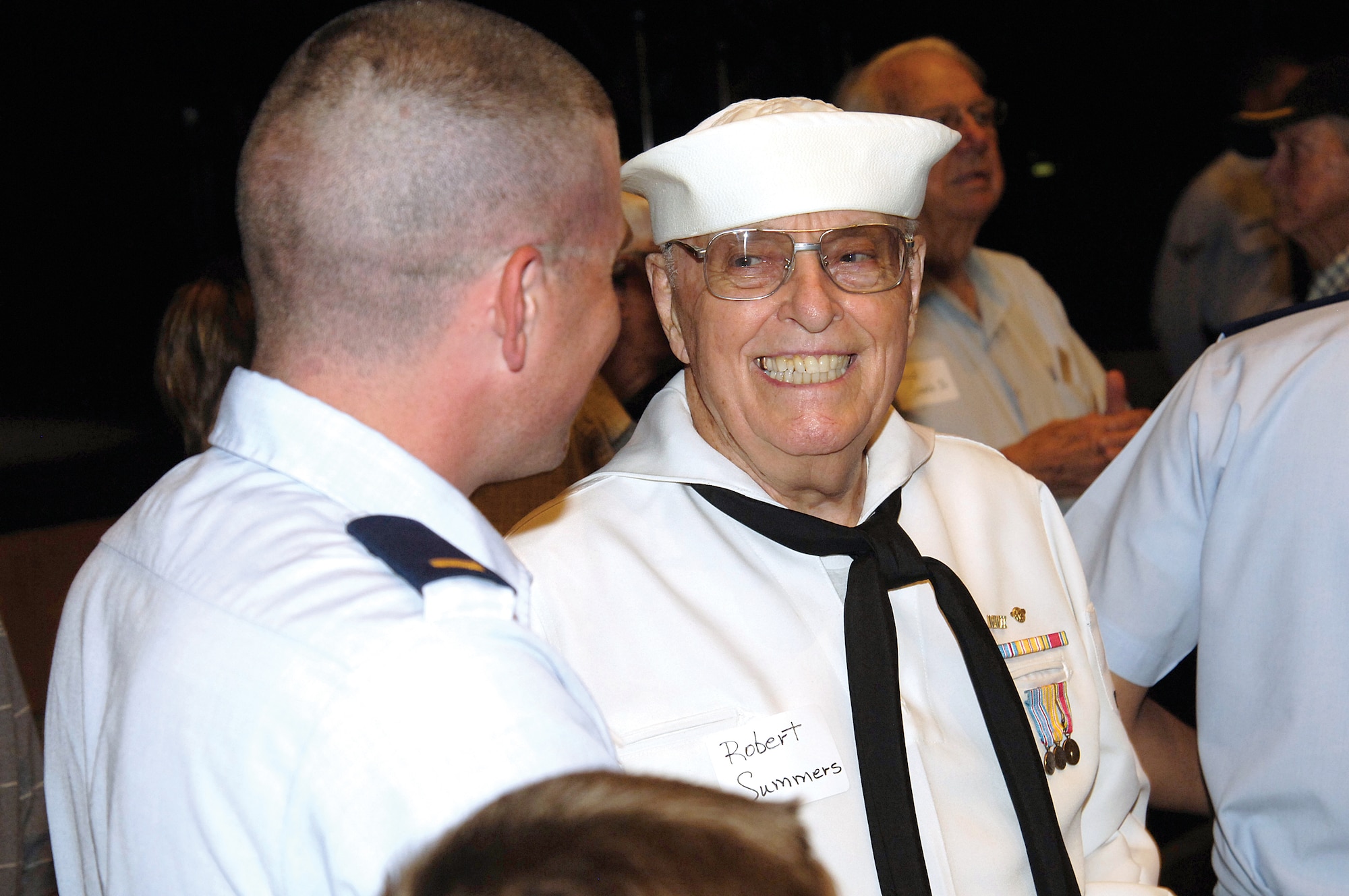 Air Force 2nd Lt. Josh Shepard, 76th Propulsion Maintenance Group, was an escort to World War II Navy veteran Robert Summers, Norman, during the ceremony at the Rose State Performing Arts Center.  Mr. Summers, who also retired from Tinker civil service in 1983 after 35 years, had to get his mother’s permission to join the Navy in 1944 as a 17-year-old; he became a motor machinist mate third class.  (Air Force photo by Margo Wright)