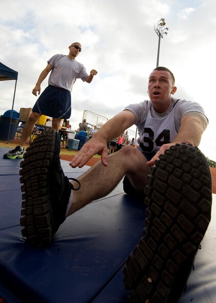 U.S. Air Force Staff Sgt. Aaron Ryder, 7th Civil Engineer Squadron, performs sit-ups while Tech. Sgt. Albert Herrera, 7th CES, encourages him to push on June 20, 2012, during the Dyess Warrior Challenge at Dyess Air Force Base, Texas. The challenge consisted of teams and individual competitors who completed a variety of exercises while being timed. Teams of four completed squats, burpees and sit-ups together and ran two miles as a pack. Individual participants completed two 400-meter laps, sit-ups, push-ups, burpees and a water jug carry. (U.S. Air Force graphic by Airman 1st Class Damon Kasberg/Released)