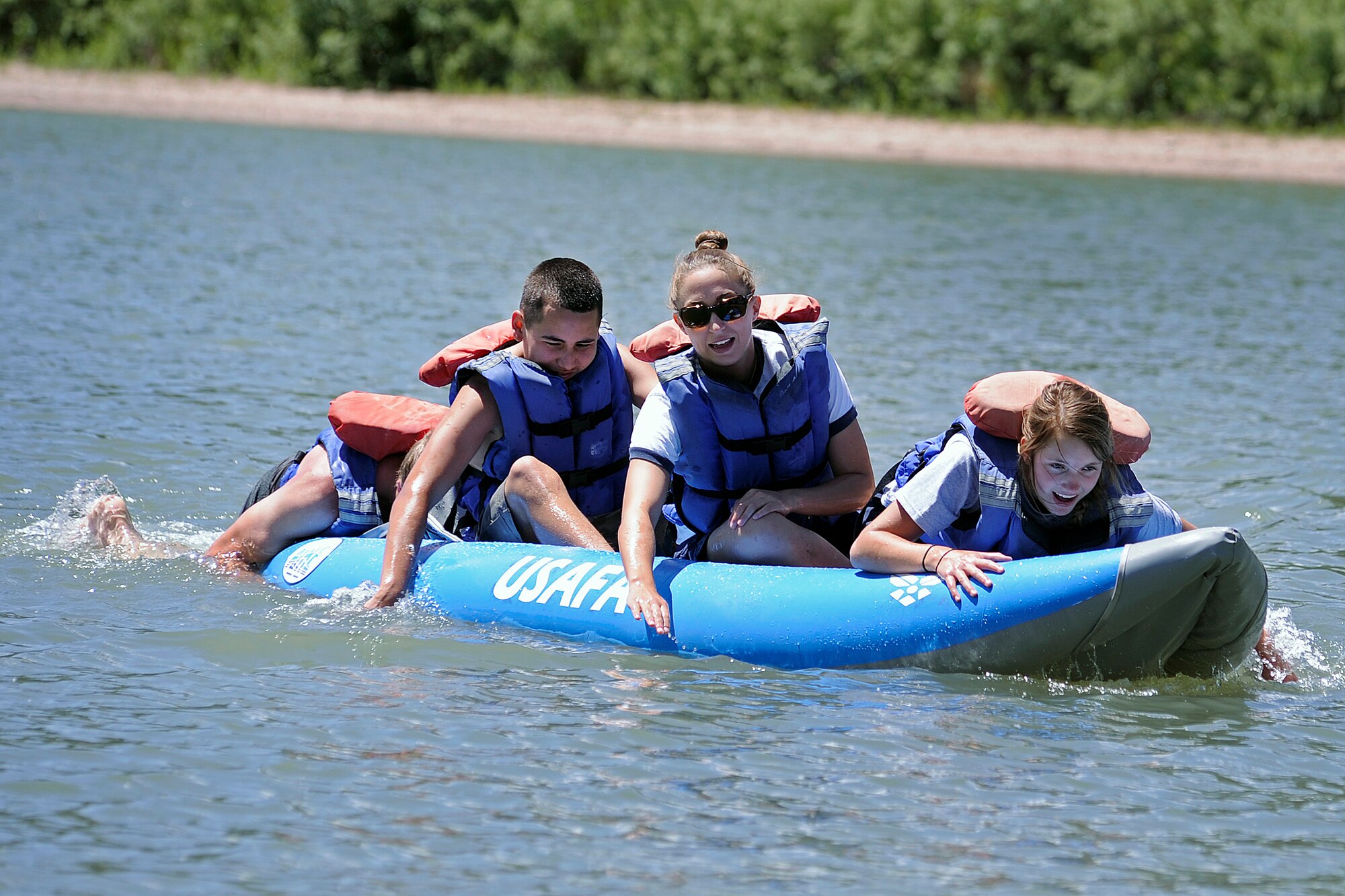 High school senior Ryan Domson (far left) pushes (left to right) high school freshman Carlos Diaz, Cadet 1st Class Lindsey Byrd and high school junior Heather Sherrill across the lake in a canoeing exercise to demonstrate teamwork. (U.S. Air Force Photo/Sarah Chambers)