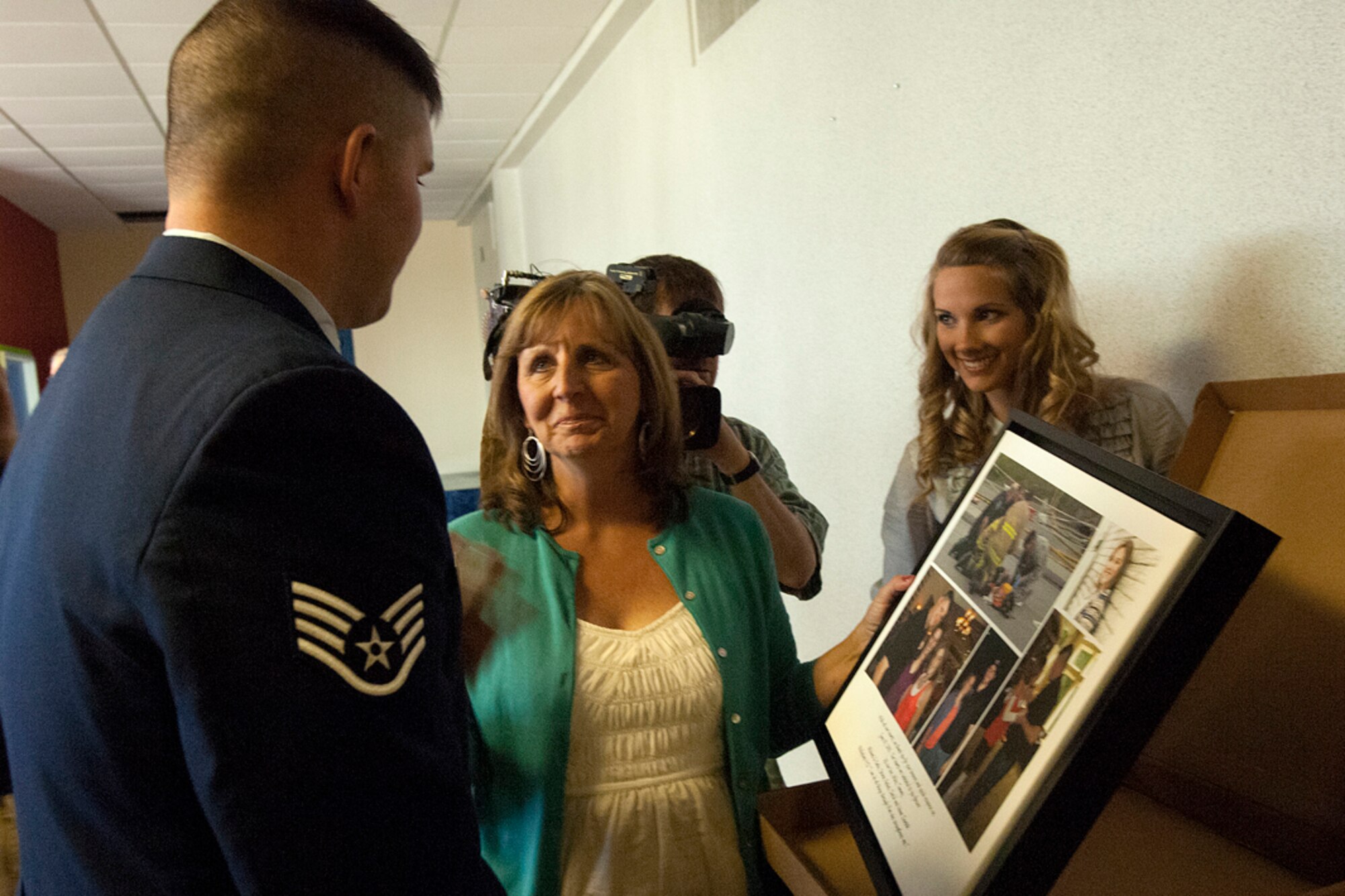 JOINT BASE ELMENDORF-RICHARDSON, Alaska -- Air Force Staff Sgt. Jacob Gibson looks at the gift Tammy Zientek, Rachel Zientek's mother, gave him  June 19, 2012. Gibson was awarded the Airman's Medal for selflessly rescuing Zientek from the wreckage of a burning plane. (U.S. Air Force photo/Airman 1st Class Omari Bernard)