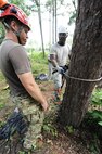 U.S. Air Force Tech. Sgt. Daniel Daubert, 347th Operations Support Squadron survival, evasion, resistance and escape specialist, checks the stance of Senior Airman Skylin Fosah, 820th Combat Operations Squadron, during a tree rescue course June 11, 2012, at Moody Air Force Base, Ga. With proper training and equipment, Fosah will be certified to safely rescue a parachutist from a tree. (U.S. Air Force photo by Master Sgt. Sonny Cohrs/Released) 
