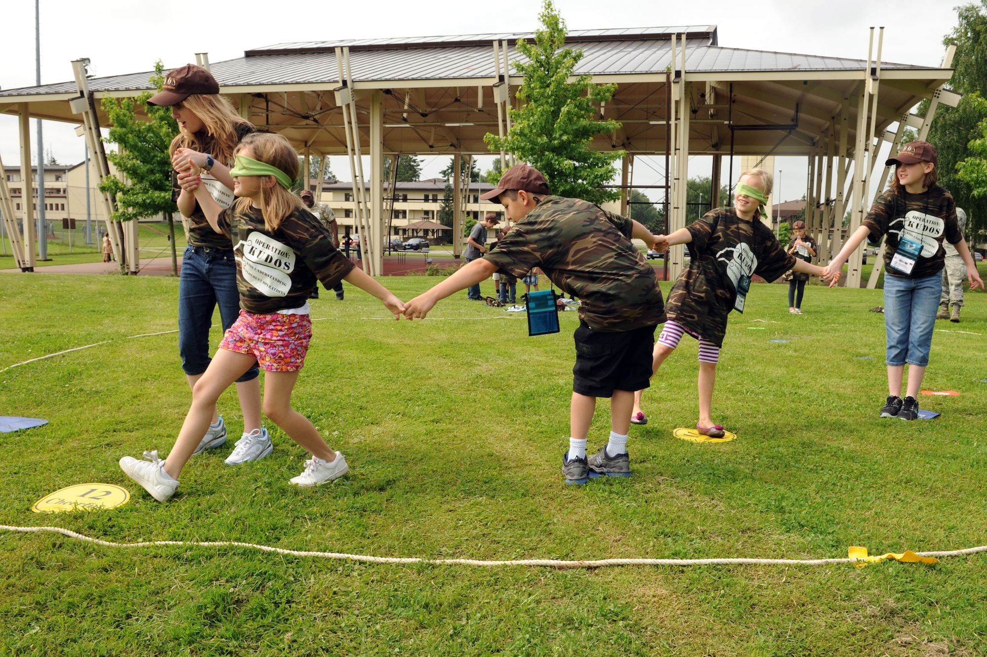 SPANGDAHLEM AIR BASE Germany --Children work together to get across the circle during a “crossing the plank” game, part of the Children Deployment Day here June 21. Some of the team building events the children participated in included crossing the plank, military dress up relay and capture the flag. (U.S. Air Force photo by Senior Airman Christopher Toon/Released)