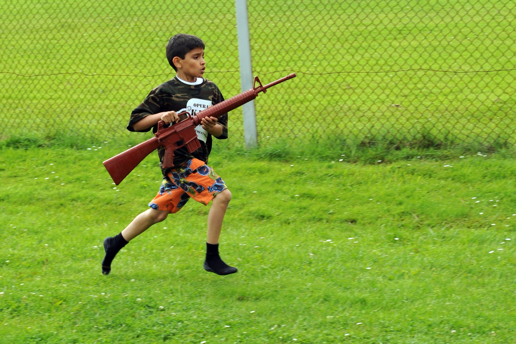 SPANGDAHLEM AIR BASE Germany-- Angel Vazquez, son of Staff Sgt. Roberto Vazquez, 52nd Civil Engineer Squadron, sprints back to the starting line during the military dress up relay race, which was one of the events held during Children Deployment Day here June 21. The event gave children the opportunity to experience different stages of the deployment process. Some of the team building events the children participated in included crossing the plank, military dress up relay and capture the flag. (U.S. Air Force photo by Senior Airman Christopher Toon/Released)