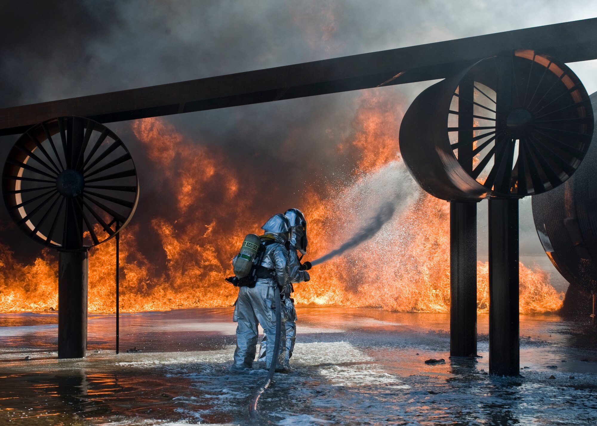 U.S. Air Force Col. David Béen, 7th Bomb Wing commander, fights a simulated aircraft fire June 20, 2012, at the Fire Department training grounds on Dyess Air Force Base, Texas. Base leadership experienced firefighting from a firefighters point of view. Training started with an exterior Jet Propellant 8 explosion, followed by an interior propane explosion in the cockpit to demonstrate the difference between the two fuel types. Firefighters are responsible for protecting Air Force assets in case of fire. Dyess’ Fire Department training grounds enable airmen to qualify on both propane and jet fuel. (U.S. Air Force photo by Airman 1st Class Peter Thompson/ Released)