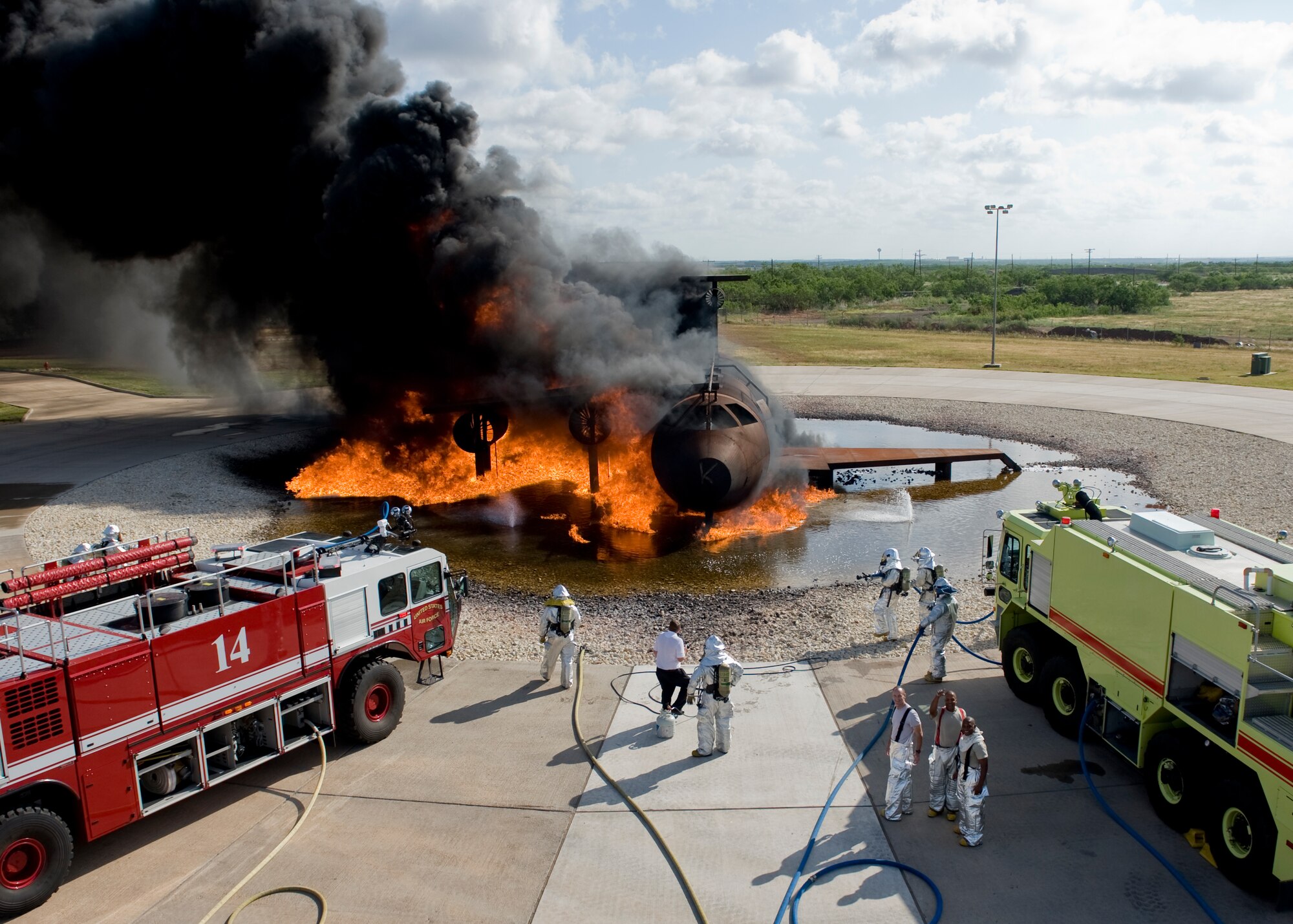 Dyess leadership and 7th Civil Engineer Squadron firefighters prepare to extinguish a simulated aircraft fire June 20, 2012, at the Fire Department training grounds on Dyess Air Force Base, Texas. Base leadership experienced firefighting from a firefighters point of view. Training started with an exterior Jet Propellant 8 explosion, followed by an interior propane explosion in the cockpit to demonstrate the difference between the two fuel types. Firefighters are responsible for protecting Air Force assets in case of fire. Dyess’ Fire Department training grounds enable airmen to qualify on both propane and jet fuel. (U.S. Air Force photo by Airman 1st Class Peter Thompson/ Released)